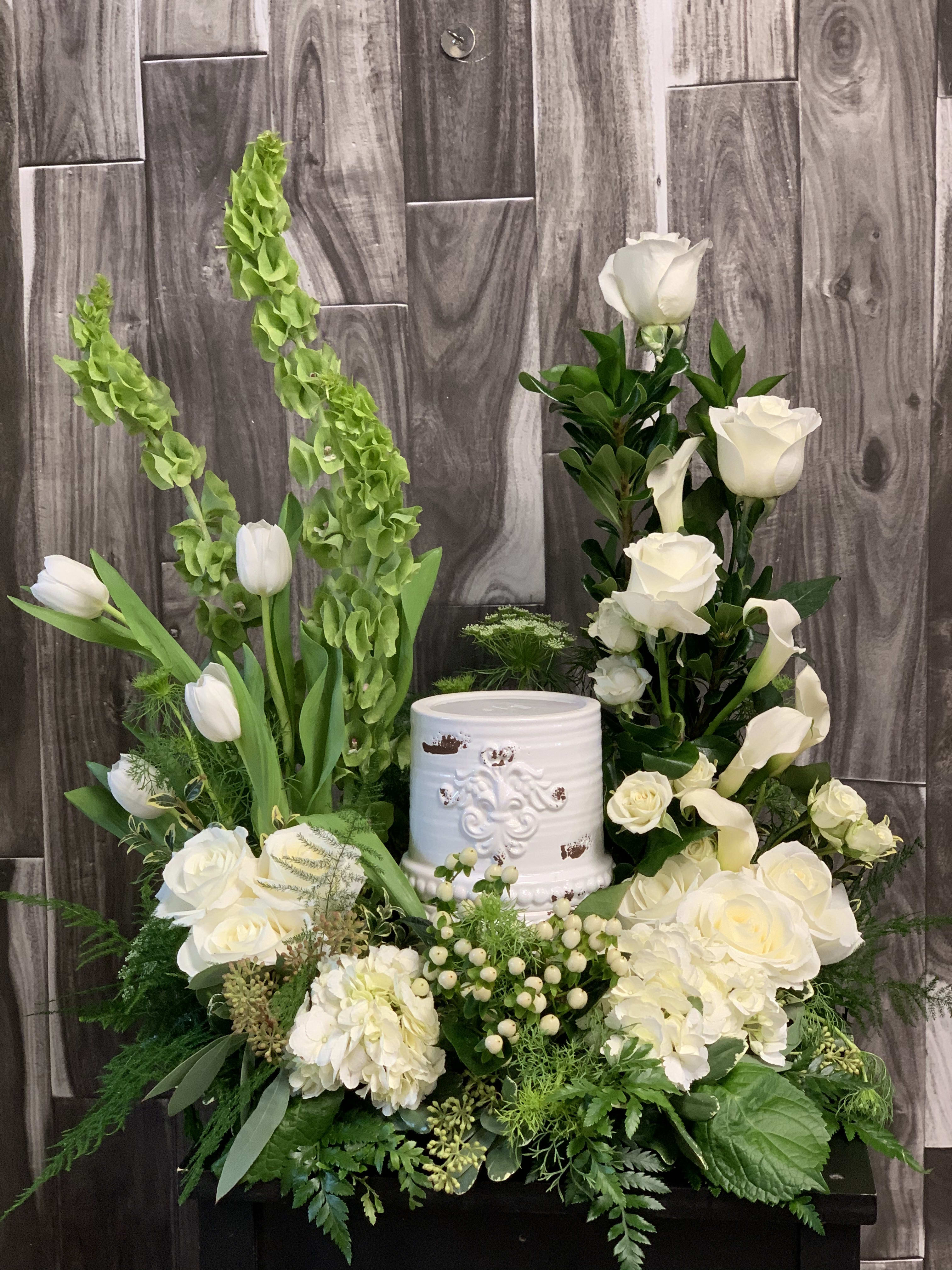 Peaceful Garden Urn Arrangement - This peaceful arrangement of white and green blooms surround the cremation vessle.
