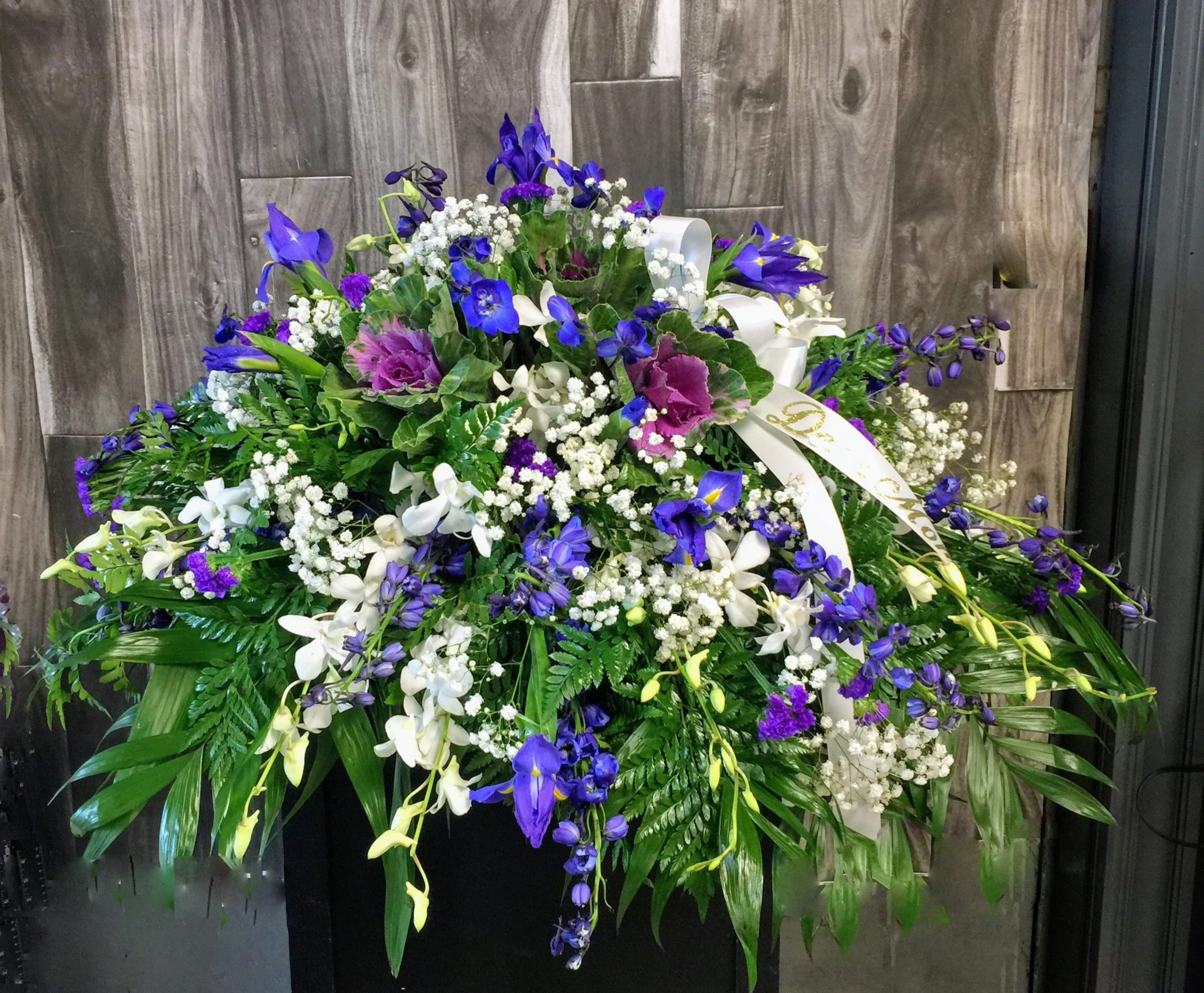Perfect Casket Spray - Express your sympathy with a lush casket spray of delphinium, iris and dendrobium orchids in gentle shades of purple and white.