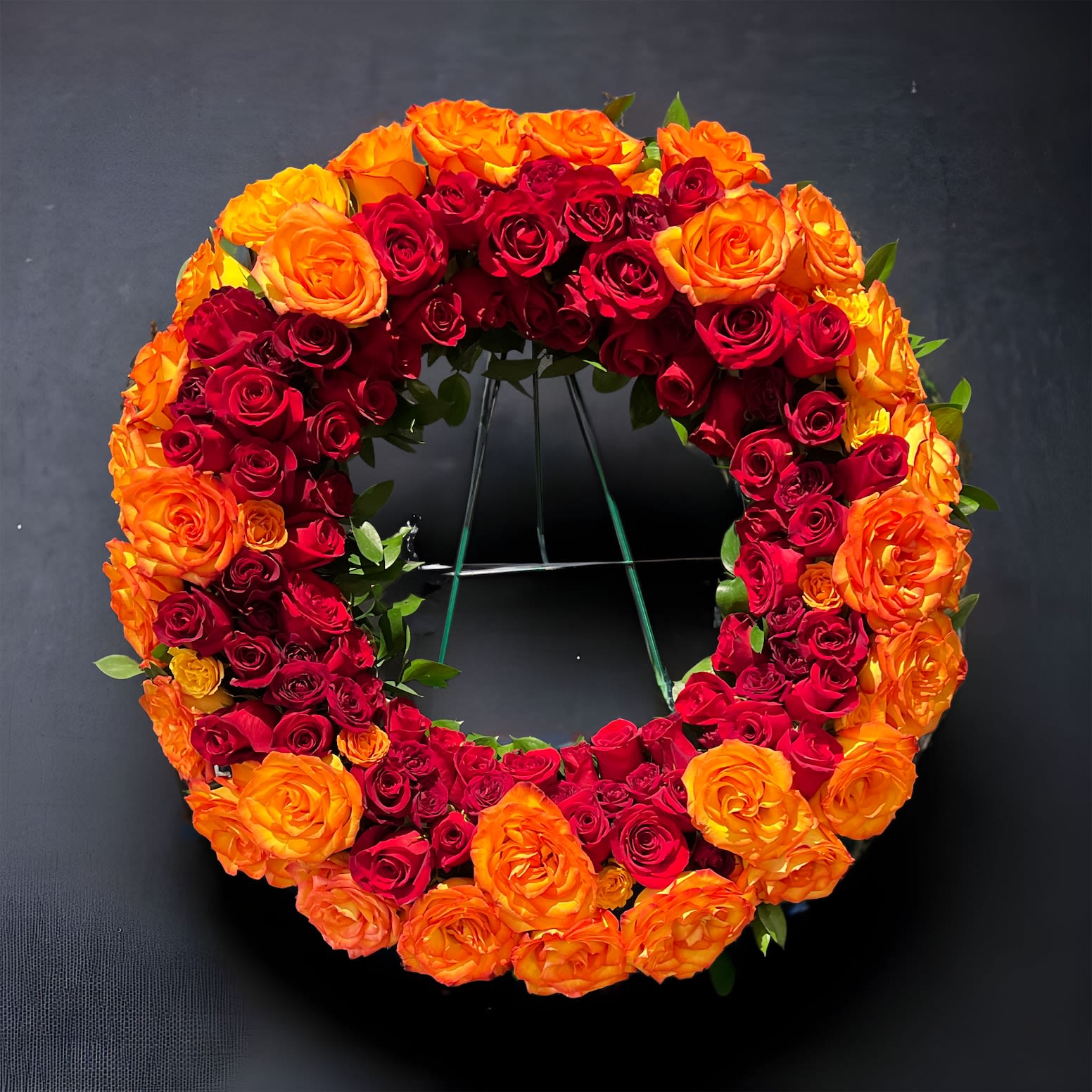 Radiant Memorial Wreath  on 60" easel - A stunning sympathy tribute of rows and rows of roses in all the fiery colors of the burning sun. Displayed on a 60" easel.  Make a heart warming tribute for your loved one.  We ask for 24-36 hours pre order due to procuring enough product.   Thank you.  Stuff here