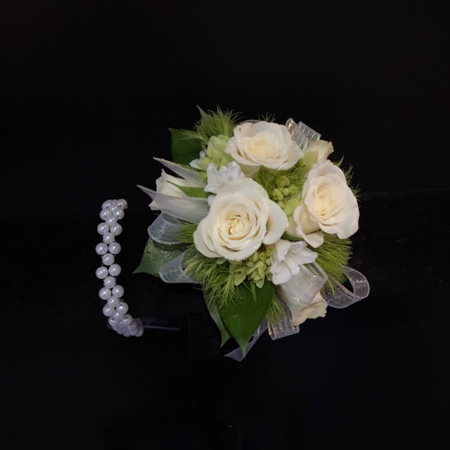 Wrist Corsage WHITE  (requires 48 hr notice) - Classic wrist corsage.. simple greens, creamy white spray roses, and white floral accents.. all on a pearl-like stretch bracelet ... perfect for prom or other special occasions.   No online substitutions.  Requires 48 hour advance order. NO same day orders. If you need a same day order or have a specific color request, please call us directly to check for pricing and availability.  615-599-9950   