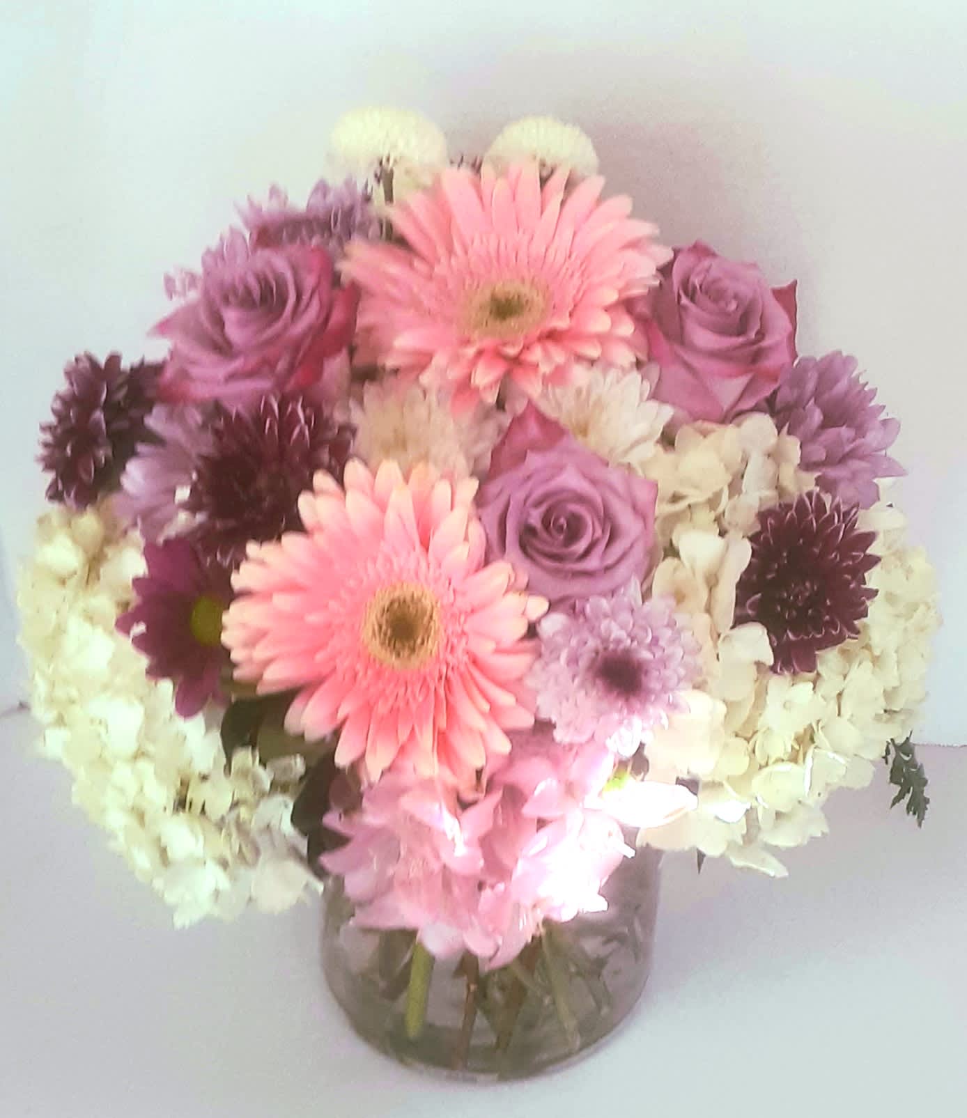 Georgia plush - Large and modern and full of assorted beautiful flowers and roses in a clear cylinder vase. Some flowers may vary