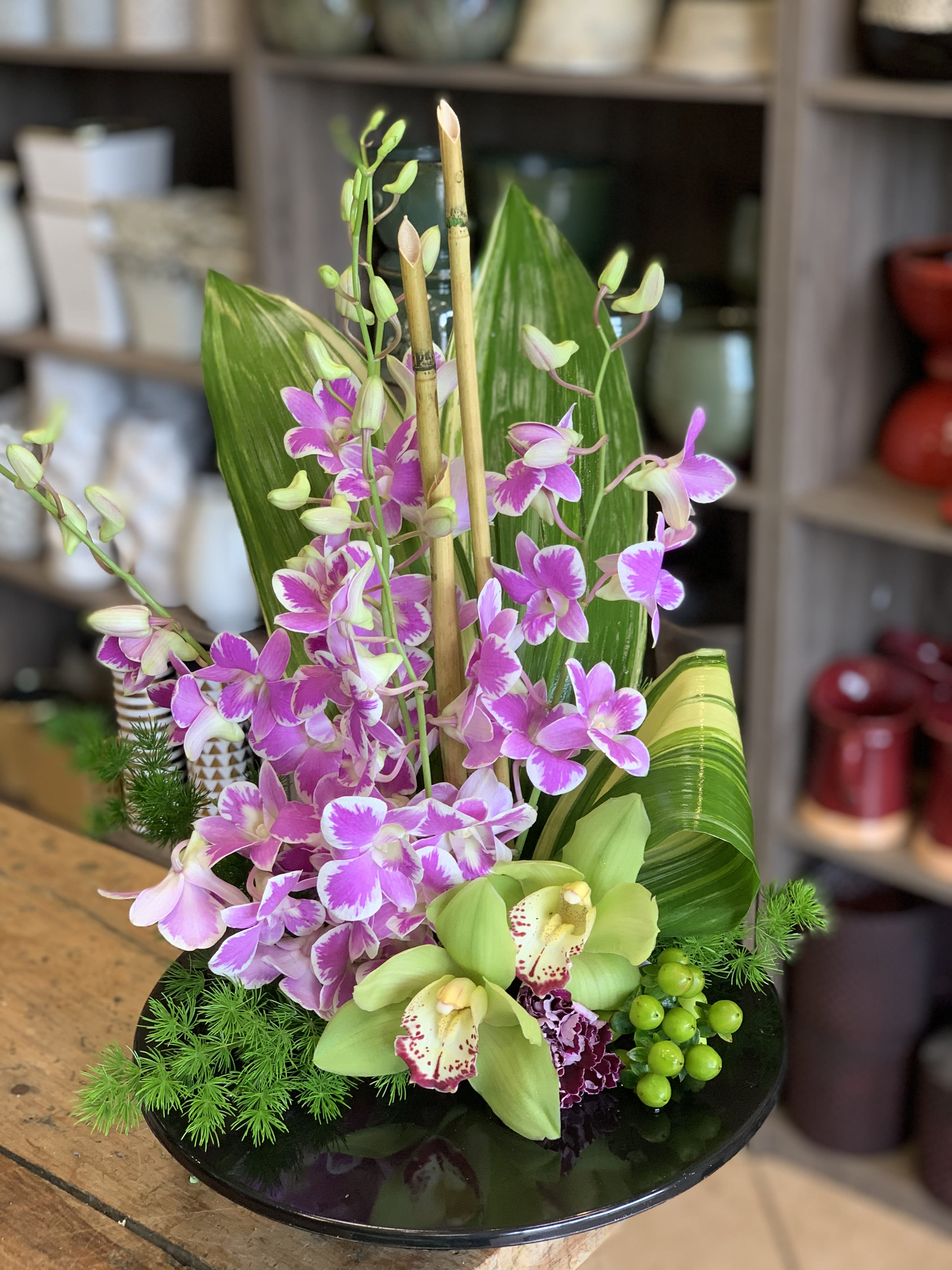Garden of Orchids - Looking more like modern sculpture than a floral arrangement, this striking bouquet surprises with delicate orchids, mini bamboo and a colorful mix of blooms. Orchids colors varies upon shop availability. 