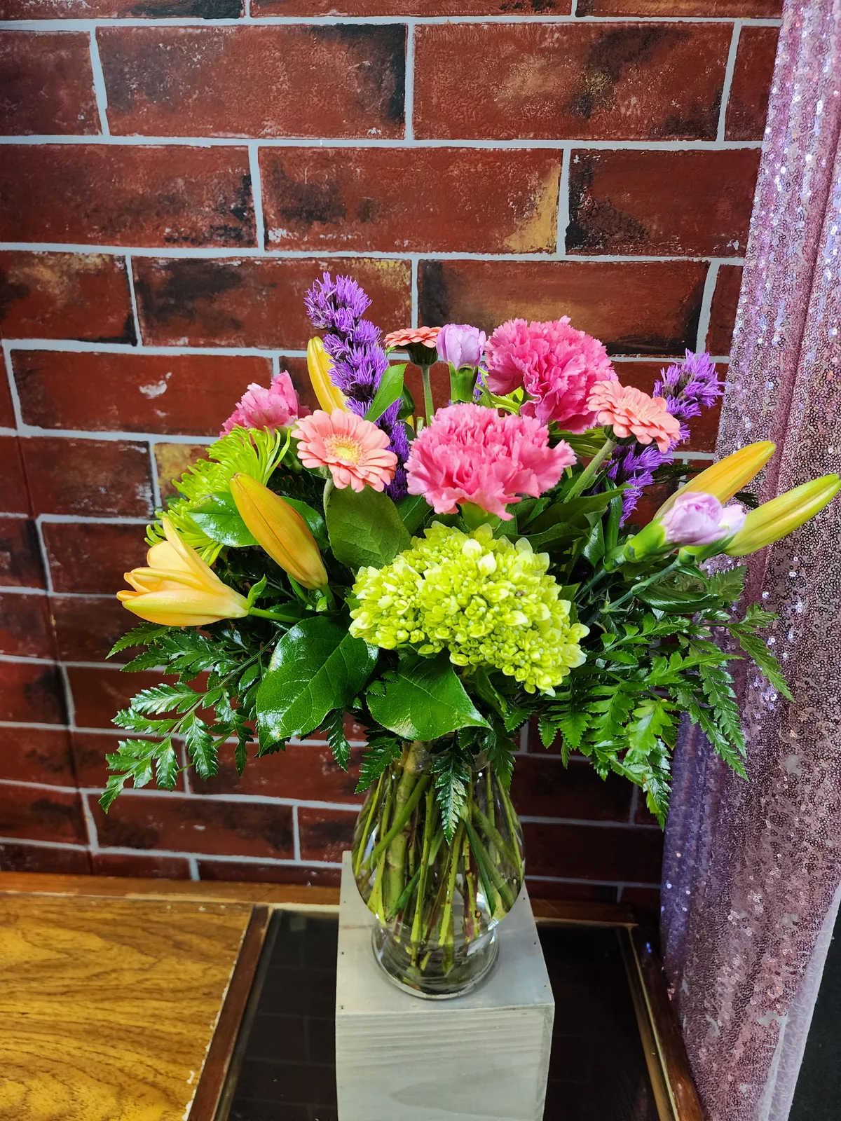 Hot and Colorful Mix - Designed with Hot colored flowers to include Hot pink carnations, Vibrant orange lilies, Liatris, Hot pink micro gerbs, lime green spider mums, hydrangea, greenery and filler flowers.  * Some stages of flower life may vary. (Example: Lilies may be more open than imaged.)  Flower shortages and product availability means that some substitutions will apply. Value will always be filled. This bouquet might include eucalyptus amongst the greenery. It may be toxic to pets including but not limited to cats and dogs if digested.