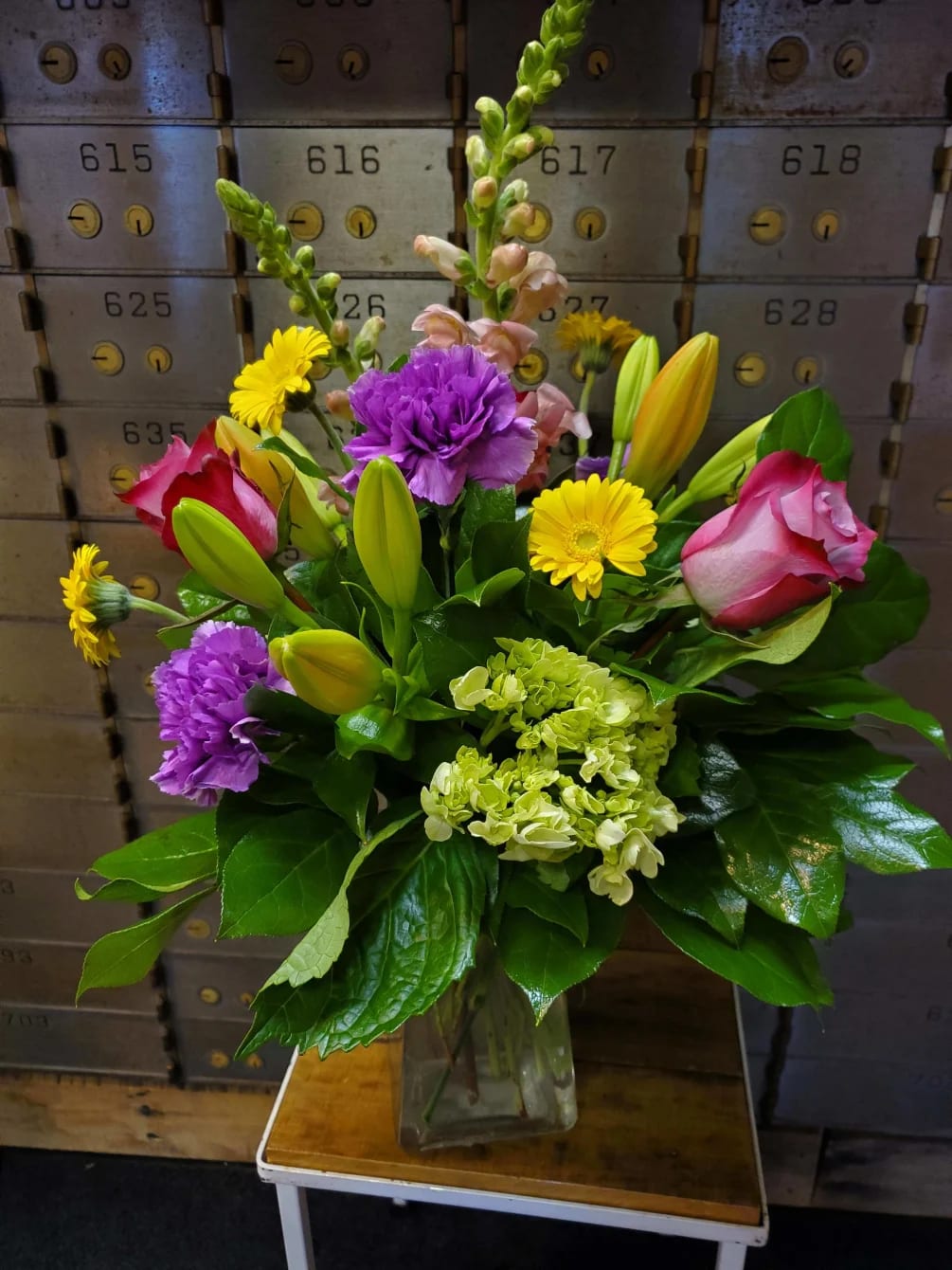 Bloom Symphony - Celebrate every moment with our Bloom Symphony Bouquet, a stunning mix of roses, micro gerberas, carnations, lilies, snapdragons, hydrangea, and complementary filler flowers. This lively arrangement blends a variety of colors, shapes, and textures for a cheerful, elegant bouquet that’s perfect for birthdays, anniversaries, or simply brightening someone’s day.  Hand-selected for freshness and artfully arranged with lush greenery, this bouquet is delivered with care by Adorkable Flowers and Gifts, creating a gift that feels as joyful as it looks.  *Some stages of flower life may vary. (Example: Lilies may be more open than imaged.) Flower shortages and product availability means that some substitutions will apply. Value will always be filled.  This bouquet might include eucalyptus amongst the greenery. It may be toxic to pets including but not limited to cats and dogs if digested.