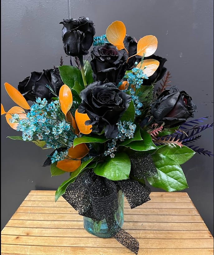 Midnight Elegance - Make a bold statement with our Midnight Elegance Bouquet, featuring striking tinted black roses paired with delicate tinted white wax flowers and lush greenery in a chic one-sided vase arrangement. This sophisticated design combines mystery and beauty, perfect for modern décor, dramatic gifts, or unforgettable centerpieces.  Each bloom is carefully selected for freshness and arranged to highlight its unique color and texture. Delivered with care by Adorkable Flowers and Gifts, the Midnight Elegance Bouquet is a captivating gift that leaves a lasting impression.  * Some stages of flower life may vary. (Example: Lilies may be more open than imaged.)  Flower shortages and product availability means that some substitutions will apply. Value will always be filled.  This bouquet might include eucalyptus amongst the greenery. It may be toxic to pets including but not limited to Cats and Dogs if digested  Designer: Susan Rademaker
