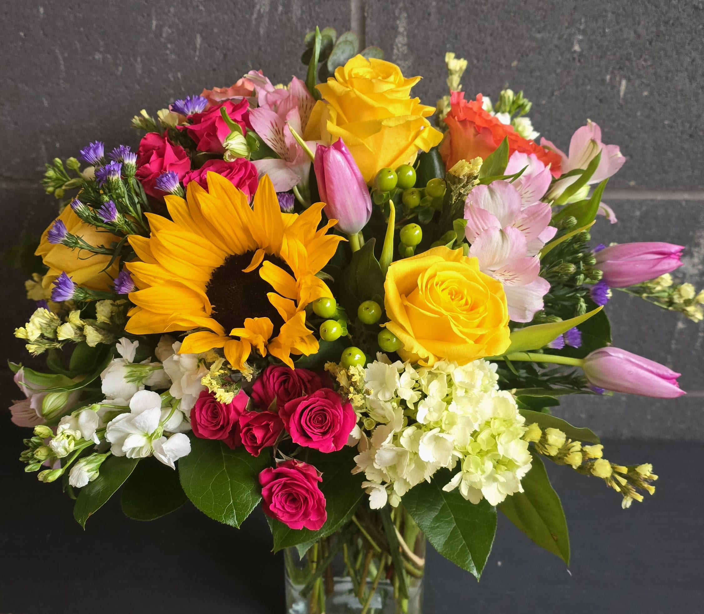 Sunburst Bliss   - Sunburst Bliss– A dazzling explosion of color and energy, this bouquet radiates joy, warmth, and celebration. Perfect for birthdays, congratulations, or anyone who needs a little extra sunshine in their day!  * Some stages of flower life may vary. (Example: Lilies may be more open than imaged.) Flower shortages and product availability means that some substitutions will apply. Value will always be filled. This bouquet might include eucalyptus amongst the greenery. It may be toxic to pets including but not limited to Cats and Dogs if digested.