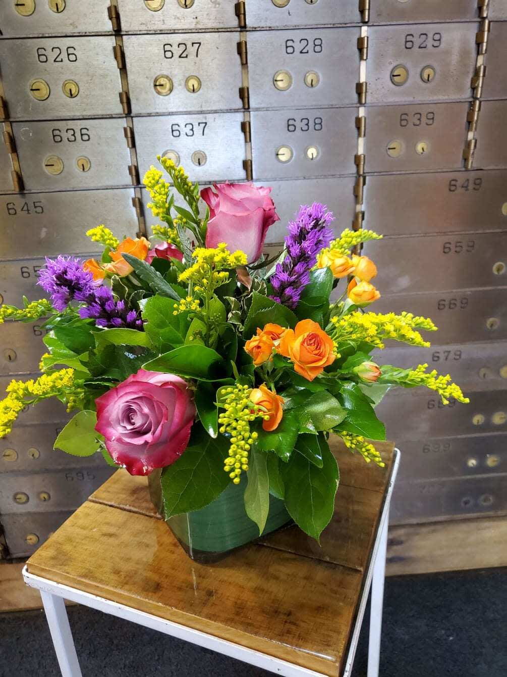 Colorful Square - A beautiful all around arrangement designed with fresh flowers to include liatris, roses, spray roses and solidago.  * Some stages of flower life may vary. (Example: Lilies may be more open than imaged.)  Flower shortages and product availability means that some substitutions will apply. Value will always be filled. This bouquet might include eucalyptus amongst the greenery. It may be toxic to pets including but not limited to Cats and Dogs if digested.
