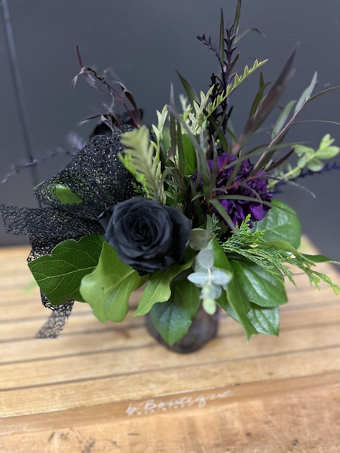 My Little Black Bouquet  - This bouquet has black roses, purple carnations and greenery.   * Some stages of flower life may vary. (Example: Lilies may be more open than imaged.)  Flower shortages and product availability means that some substitutions will apply. Value will always be filled. This bouquet might include eucalyptus amongst the greenery. It may be toxic to pets including but not limited to Cats and Dogs if digested.