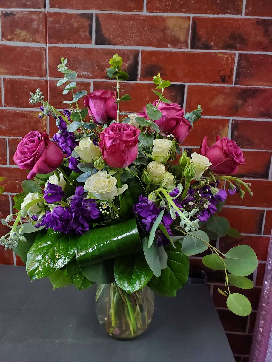 Designed for You - This bouquet is designed one sided in standard clear vase. This bouquet has pink roses, white spray roses and purple stock.   *Some stages of flower life may vary. (Example: Lilies may be more open than imaged.)  Flower shortages and product availability means that some substitutions will apply. Value will always be filled.  This bouquet might include eucalyptus amongst the greenery. It may be toxic to pets including but not limited to Cats and Dogs if digested.