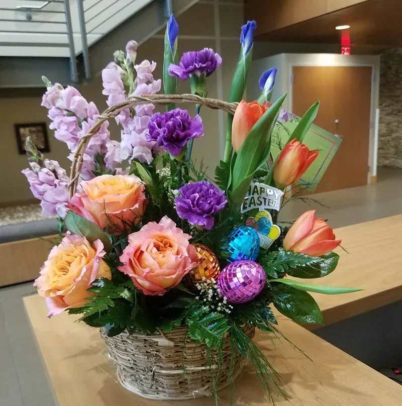 Easter Basket of Blooms - Enjoy a simple sweet basket full of beautiful blooms with fun easter decor to just add a special touch to this special day.  * Some stages of flower life may vary. (Example: Lilies may be more open than imaged.) Flower shortages and product availability means that some substitutions will apply. Value will always be filled. This bouquet might include eucalyptus amongst the greenery. It may be toxic to pets including but not limited to Cats and Dogs if digested.