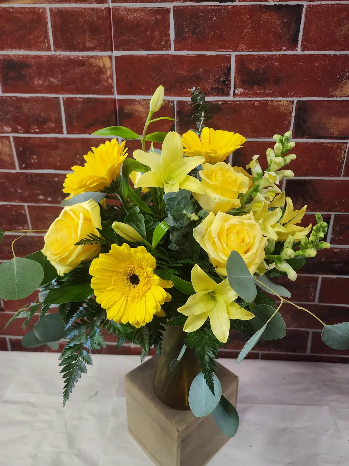 Everything in Yellow - This is an all around design that is a mix of the best available yellow flowers. These flower could include yellow roses, yellow snap dragon, Yellow daisies, Yellow lilies, Yellow carnations, and a mix of greens in a vase.  * Some stages of flower life may vary. (Example: Lilies may be more open than imaged.)  Flower shortages and product availability means that some substitutions will apply. Value will always be filled. This bouquet might include eucalyptus amongst the greenery. It may be toxic to pets including but not limited to Cats and Dogs if digested.