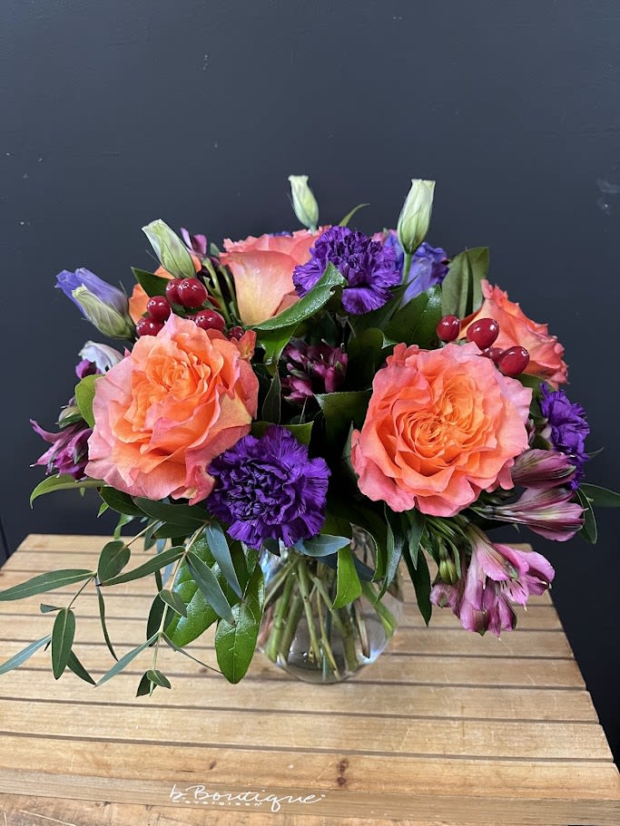 Free Spirit - This is an all around bouquet with Free spirit roses, medium purple moon carnations, red hypericum berries and purple alstroemeria.  *Some stages of flower life may vary. (Example: Lilies may be more open than imaged.)  Flower shortages and product availability means that some substitutions will apply. Value will always be filled. This bouquet might include eucalyptus amongst the greenery. It may be toxic to pets including but not limited to Cats and Dogs if digested.