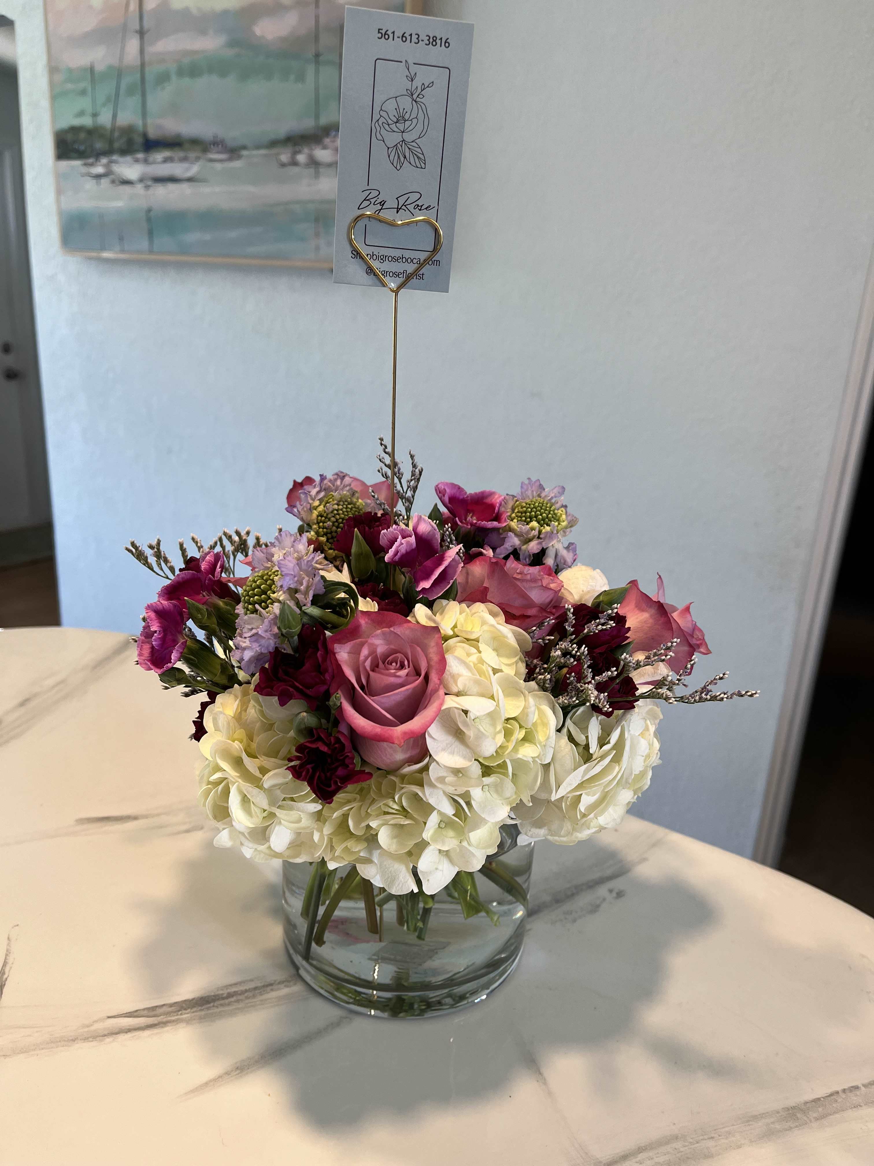 plum perfection - our sleek cylinder with premium white hydrangea purple roses and purple accent flowers. 