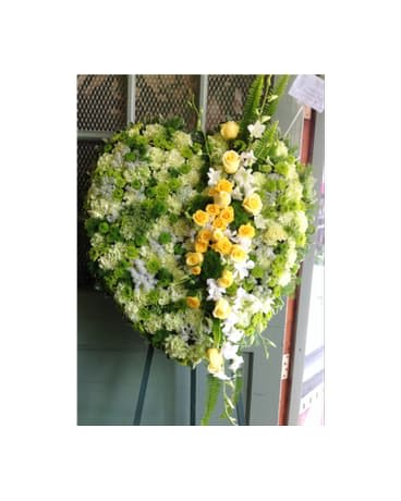 FROM YOUR HEART - SYM-076 - A beautiful solid heart with green and yellow flowers.  Picture is Premium size.  Flower selection subject to availability.  **Prices may vary for non local delivery.