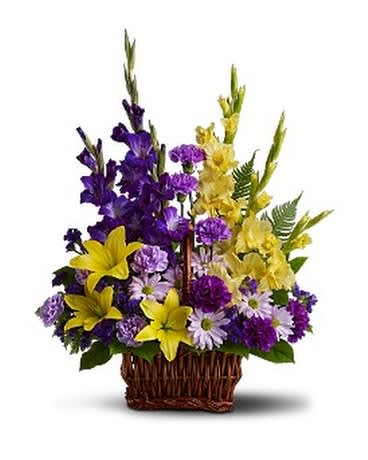 BASKET OF MEMORIES - Honor rich remembrances of one dearly missed with a vivid mix of blooms that offer strength and comfort alike during a time of sorrow. Beautiful fresh flowers such as yellow asiatic lilies and gladioli contrast with purple carnations, statice and gladioli, plus lavender carnations and chrysanthemums in a rectangular basket with handle.  