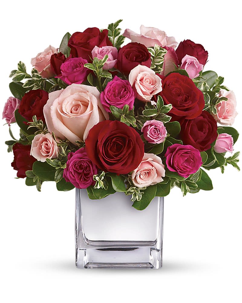 Love Medley Bouquet with Red Roses - Sing her a love song - with flowers. This lush, loving rose arrangement tells her just how much you care. The stylish bouquet features large red and pink roses accented with smaller spray roses in shades of red and pinks. Delicate green oregonia and pittosporum add a fresh contrast, and all comes arranged and delivered in our exclusive Mirrored Silver Cube vase.Approximately 10 1/2" W x 11" H