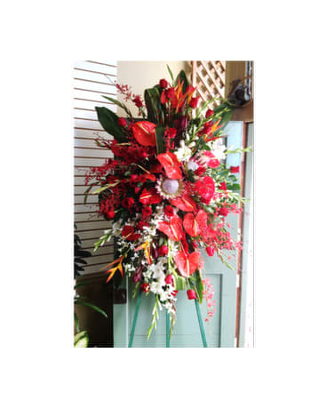 SYMPATHY SPRAY - SYM-115 - A beautiful standing spray with vibrant red hues.  Flower selection subject to availability.  ***Prices may vary for non-local delivery.***