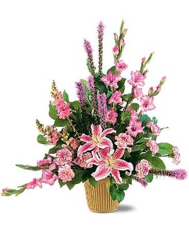 TRIUMPHANT TRIANGLE - This beautiful arrangement with its purple and pink flowers reminds us that love carries on. One arrangement with lavender gladioli, purple liatris, pink snapdragons and lilies, and soft cascading foliage arrives in a simple green container.  Approximately 31" W x 33" H