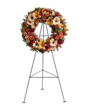 WREATH OF REMEMBRANCE - A standing wreath of fresh flowers such as roses, Asiatic lilies, carnations, gerbera and stock, in shades of peach, orange and red - accented with greenery - is delivered on an easel. A standing wreath of fresh flowers such as roses, Asiatic lilies, carnations, gerbera and stock, in shades of peach, orange and red – accented with greenery – is delivered on an easel. 