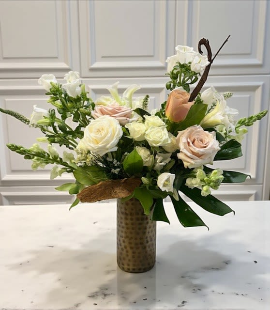 Velvet Earth - An elegant tall arrangement that blends soft blush and dusty tones with creamy whites and rich natural textures. Designed in a bronze vase, Velvet Earth captures the warmth of grounded luxury — where organic elements meet refined beauty, creating a composition that feels both modern and timeless.
