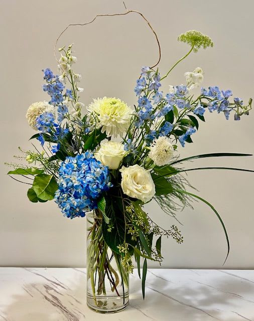 Blue Moon Light  - Blue Moon Light is a stunning floral arrangement featuring a harmonious blend of blue and white flowers. The soft, soothing tones evoke a sense of calm and elegance, making it the perfect choice for adding a serene touch to any occasion or space.