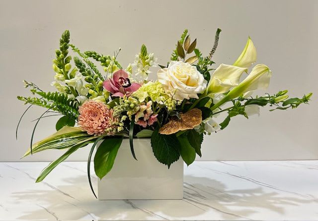 Soft &amp; Blush - Delicate and refined, Soft &amp; Blush is an upscale floral arrangement that exudes grace and sophistication. A harmonious blend of whites and blush tones, accented with an exquisite orchid bloom atop for a touch of luxury. 