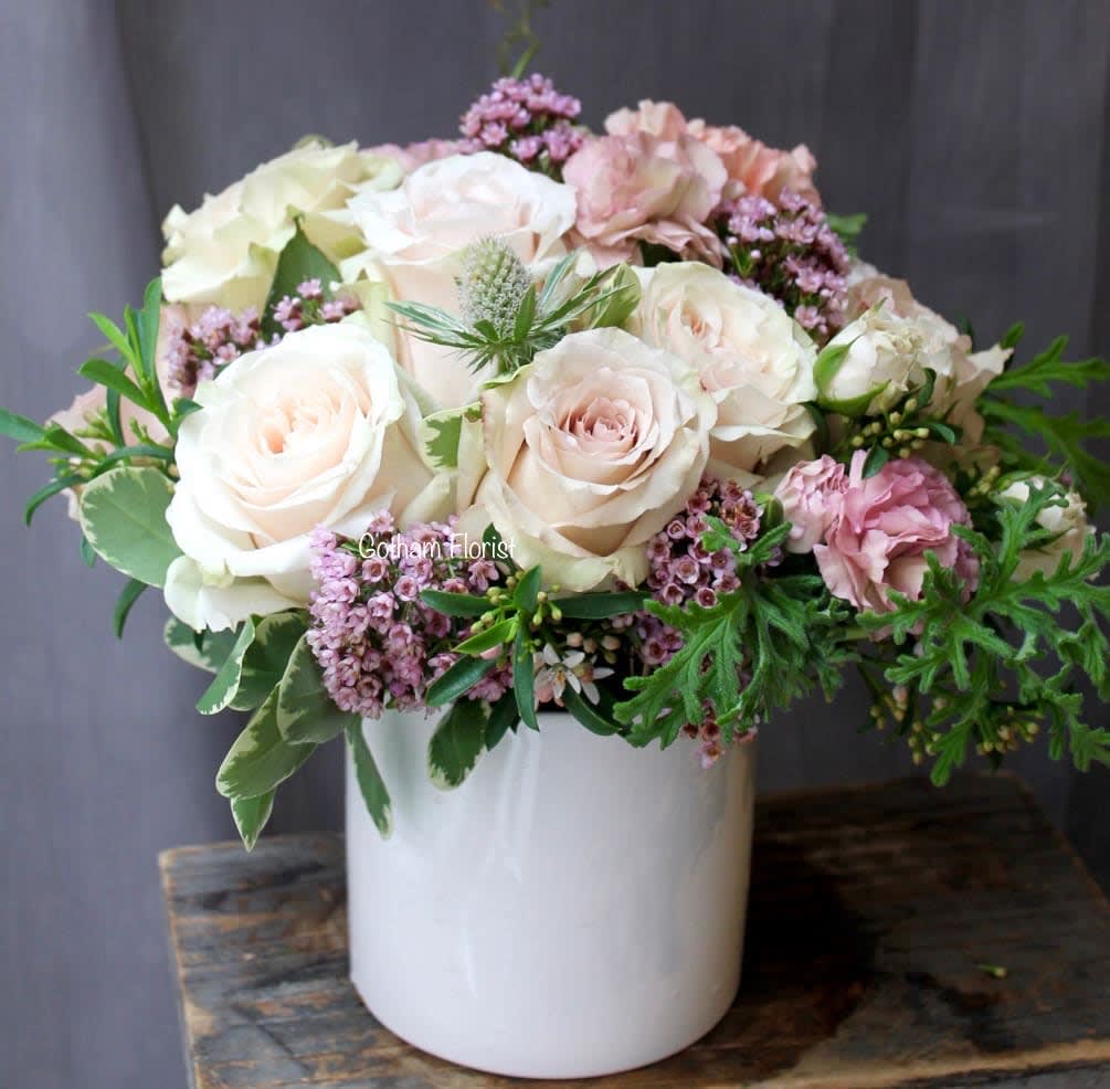 Cherish - A perfect peach and pink combination with roses, carnations and spray roses in small 4 inch white ceramic vase. A perfect cute arrangement to brighten someones day. Same day flower delivery in manhattan.