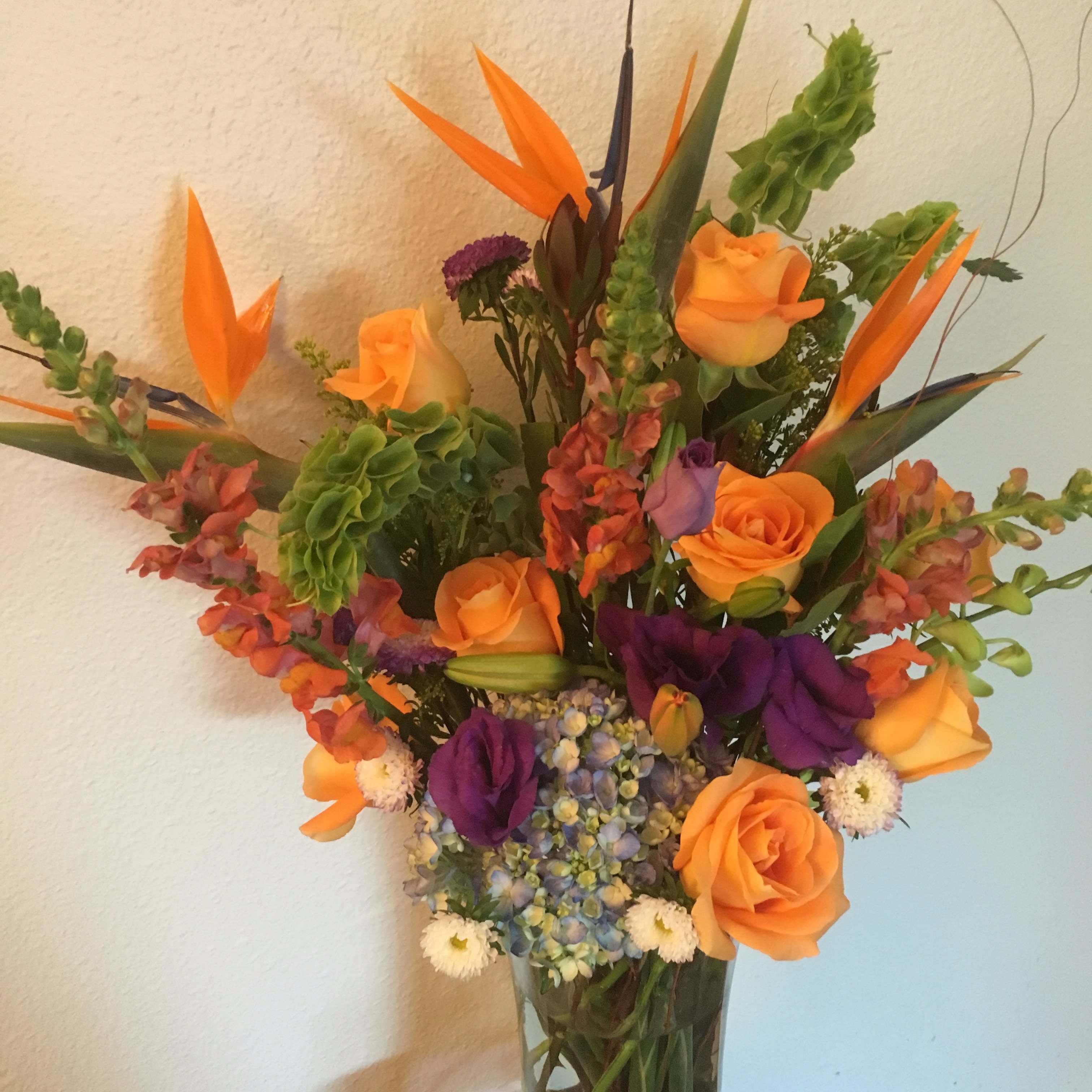 Uptown - A delightful arrangement of Birds of paradise,Orange roses,purple lysianthus,Hydrengias,Snap dragons and Irish bells will send your message in the most special way.