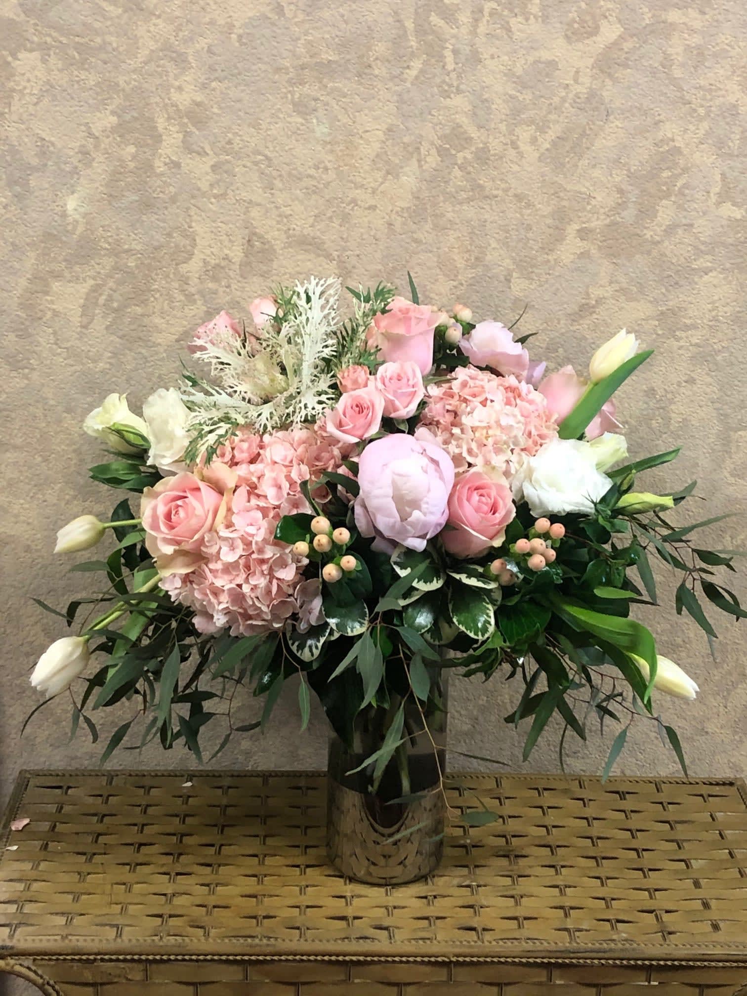 Adore You - Type of Flowers: Pink Peonies, Pink Hydrangeas, Pink Roses, White Lisianthus, White Tulips, Pink Hypericum Berries and Peacock Kale in a medium vase. Availability: December-June Substitute Available: Yes Design View: All Facing View Photo shown: Regular