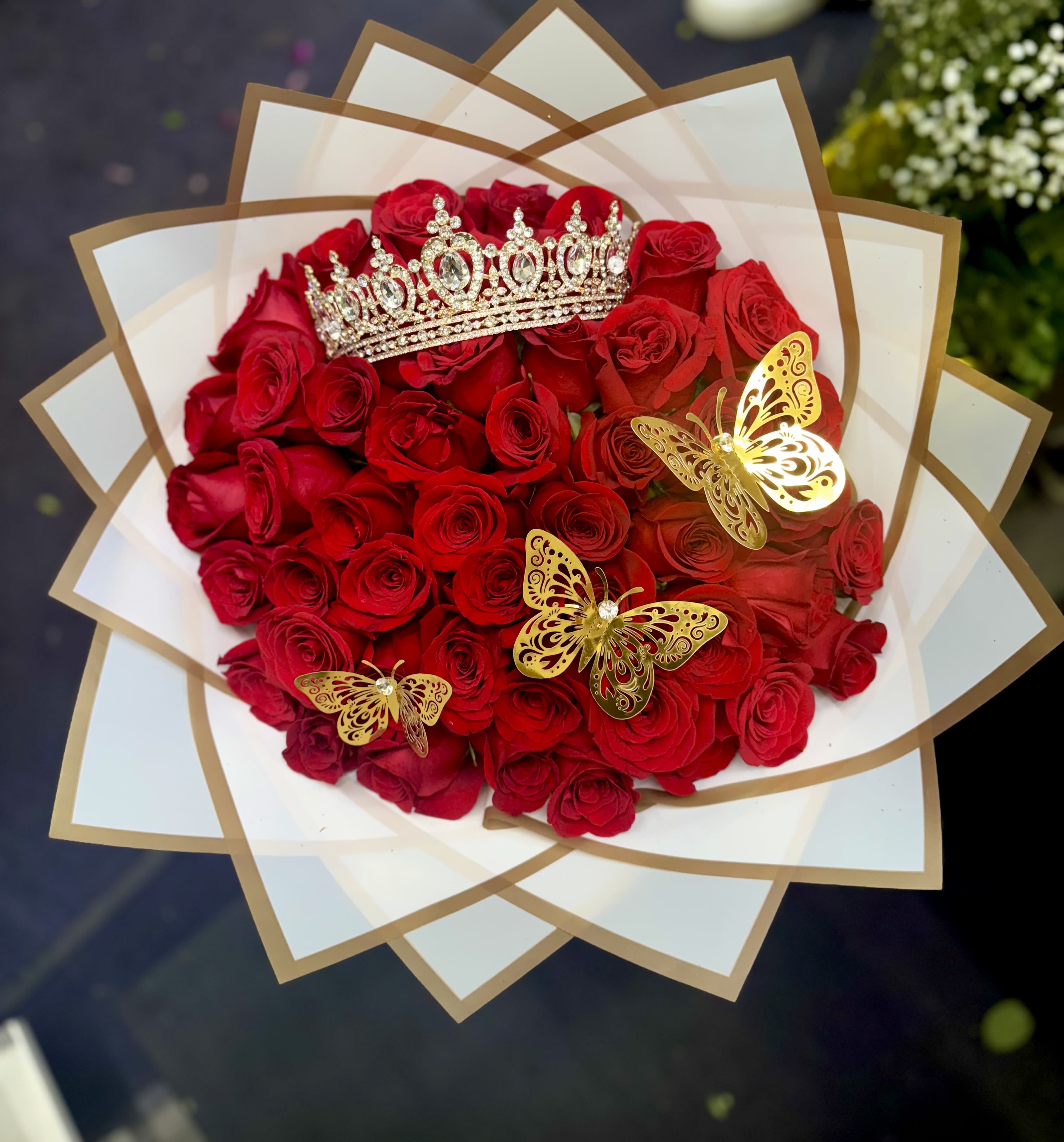 Eternal Love” Bouquet – 50 Red Roses - A breathtaking bouquet of 50 red roses, wrapped in delicate Korean-style paper and adorned with a charming crown and butterflies, symbolizing love, beauty, and devotion. Perfect for expressing deep emotions on Valentine’s Day or any day of the year.  Made primarily with red roses. Wrapping and accents may vary depending on availability, while maintaining the essence and elegance of the arrangement.