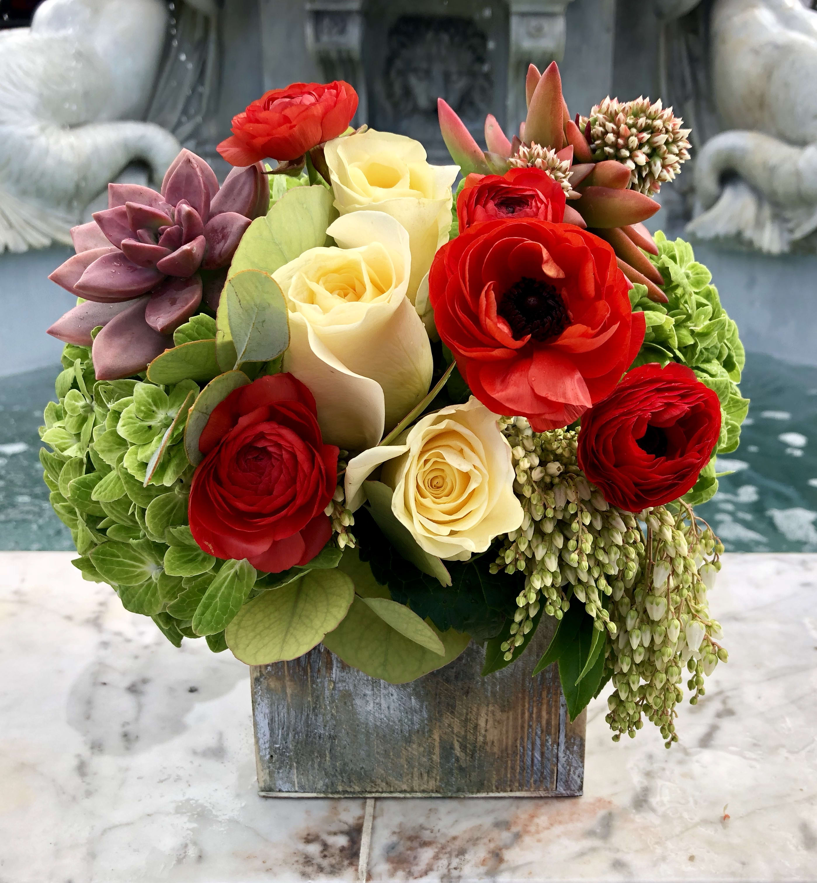 COASTAL HILL  - This green Hydrangea blended with red ranunculous and soft roses and succulents nestled in a wooden box. This one is a show stopper!