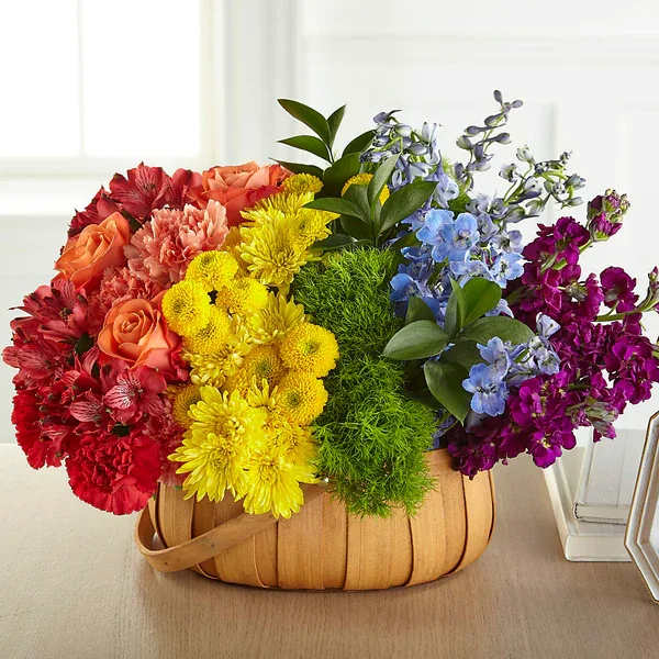 Prideful Basket - Our Prideful Basket shares support and comfort during times of sensitivity. This arrangement is designed with a mix of truly unique flowers in each bold shade of the rainbow to remind loved ones of how much you truly care about them and the one you are remembering.  Please Note: The bouquet pictured reflects our original design for this product. While we always try to follow the color palette, we may replace stems to deliver the freshest bouquet possible, and we may sometimes need to use a different vase.
