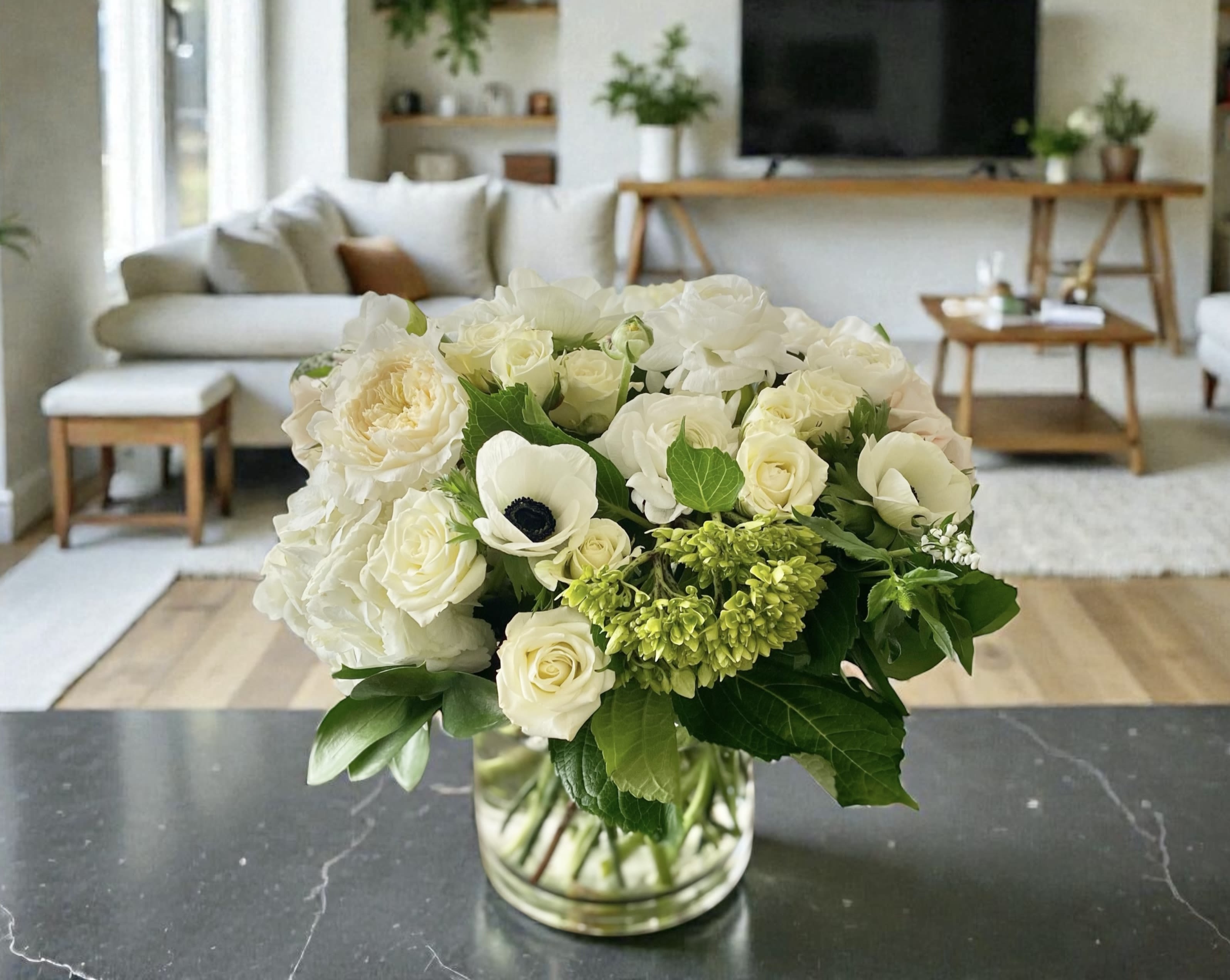 Pure White  - Pure, serene and comforting. Designed and hand-crafted with a variety of seasonal, fresh, high-end flowers in a white color palette. Container is a 6" glass or ceramic white vase. Pictures are not exact duplicates of what we will be making, but rather are samples of our creations and design style. However we will make every effort to stock and use flowers shown. arrangements will be DESIGNERS CHOICE based on flower availability in the particular COLOR PALETTE you are choosing. For same day delivery, call us at 949-682-5004.