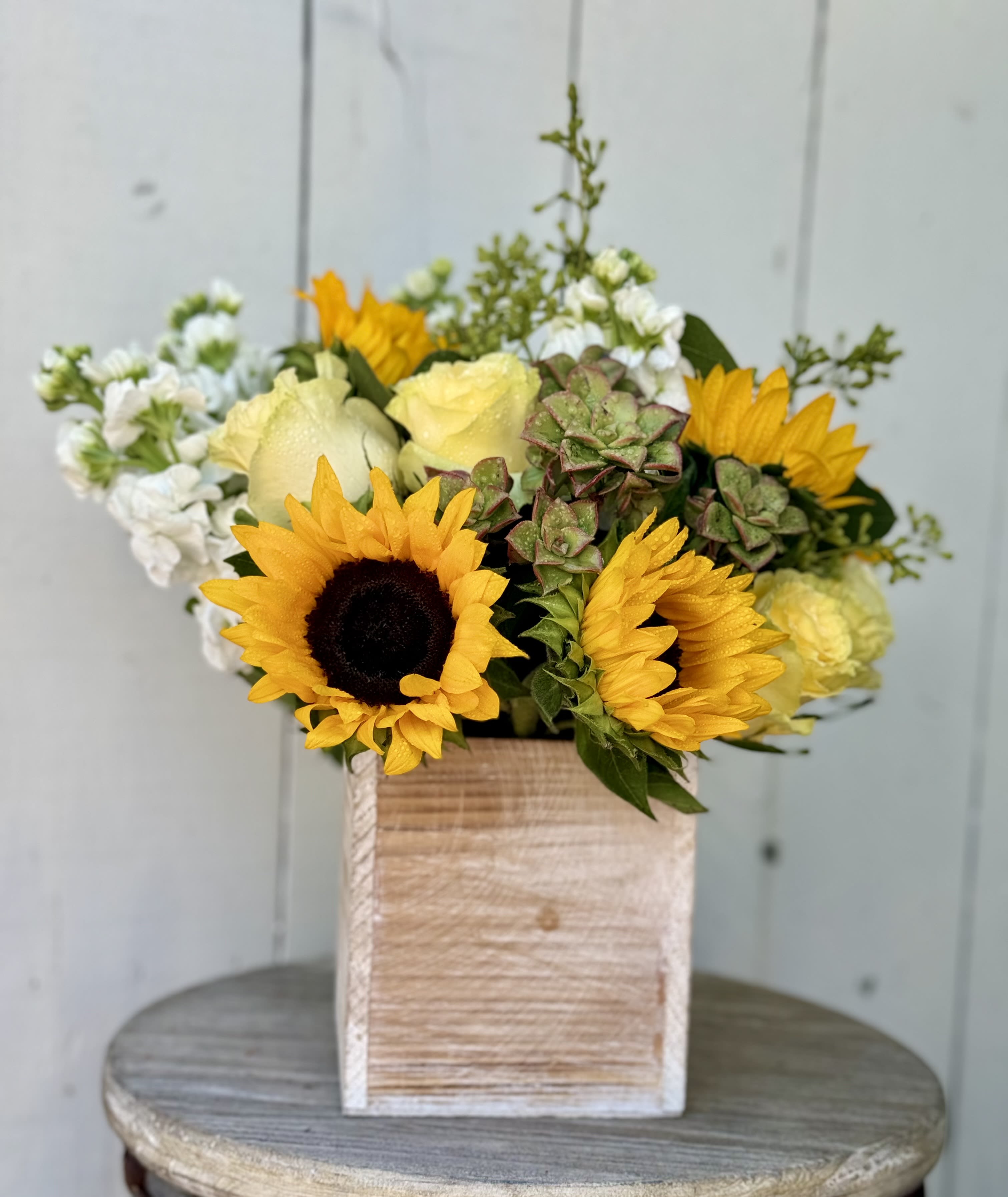 LITTLE SUNFLOWER BOUQUET  - A really cute sunflower and yellow roses with white stock and a succulent. This comes designed in a 5x5 wooden container.