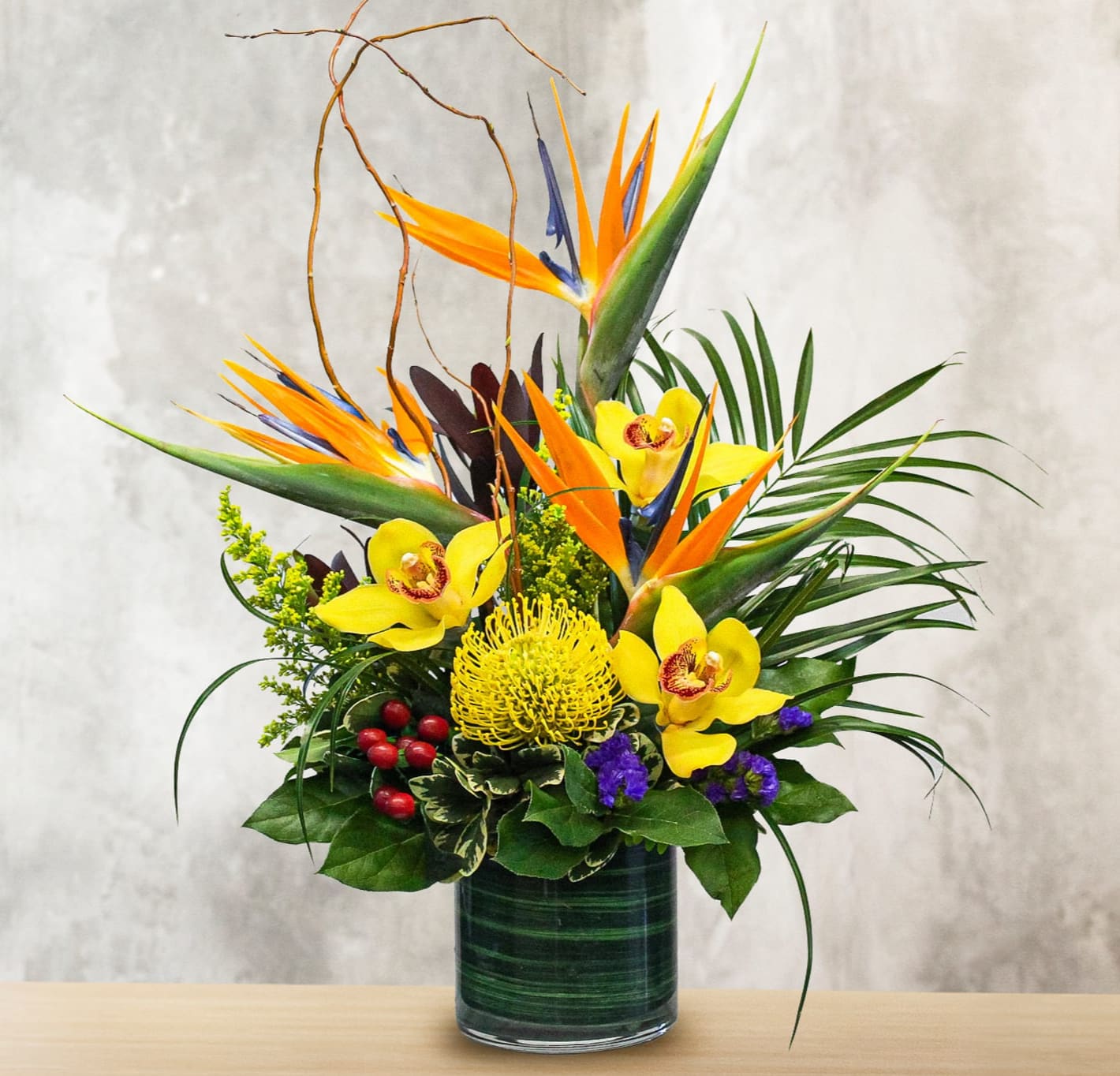 Aloha - This unique design includes birds of paradise, cymbidium orchids, pin cushion protea, safari sunset, hypericum berries, statice, and tropical foliage. 