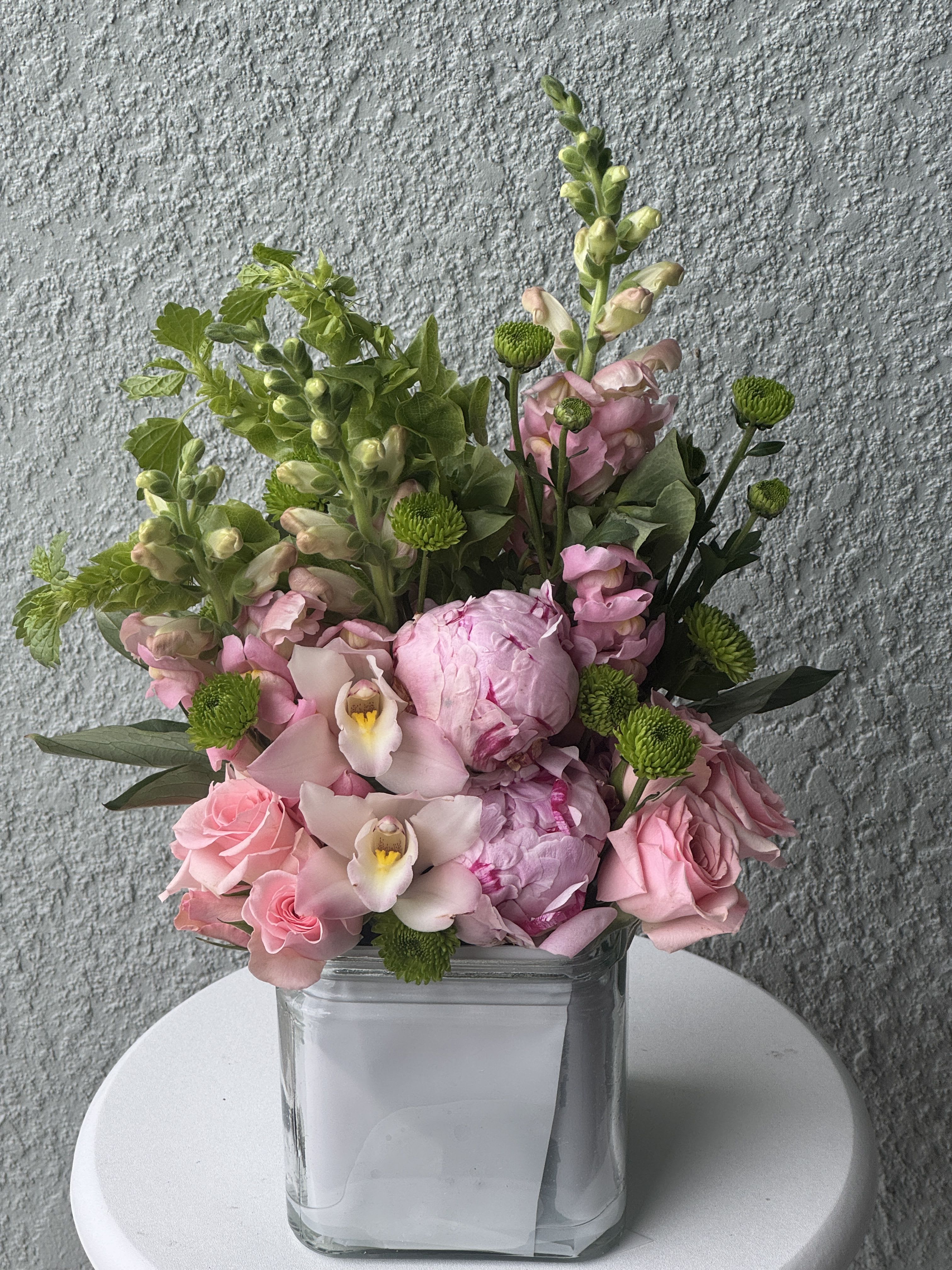 Bliss Garden Peonies  - A romantic blend of soft pink peonies accented with fresh seasonal greens. This arrangement captures effortless beauty and grace, making it perfect for birthdays, celebrations, or simply to brighten someone’s day.