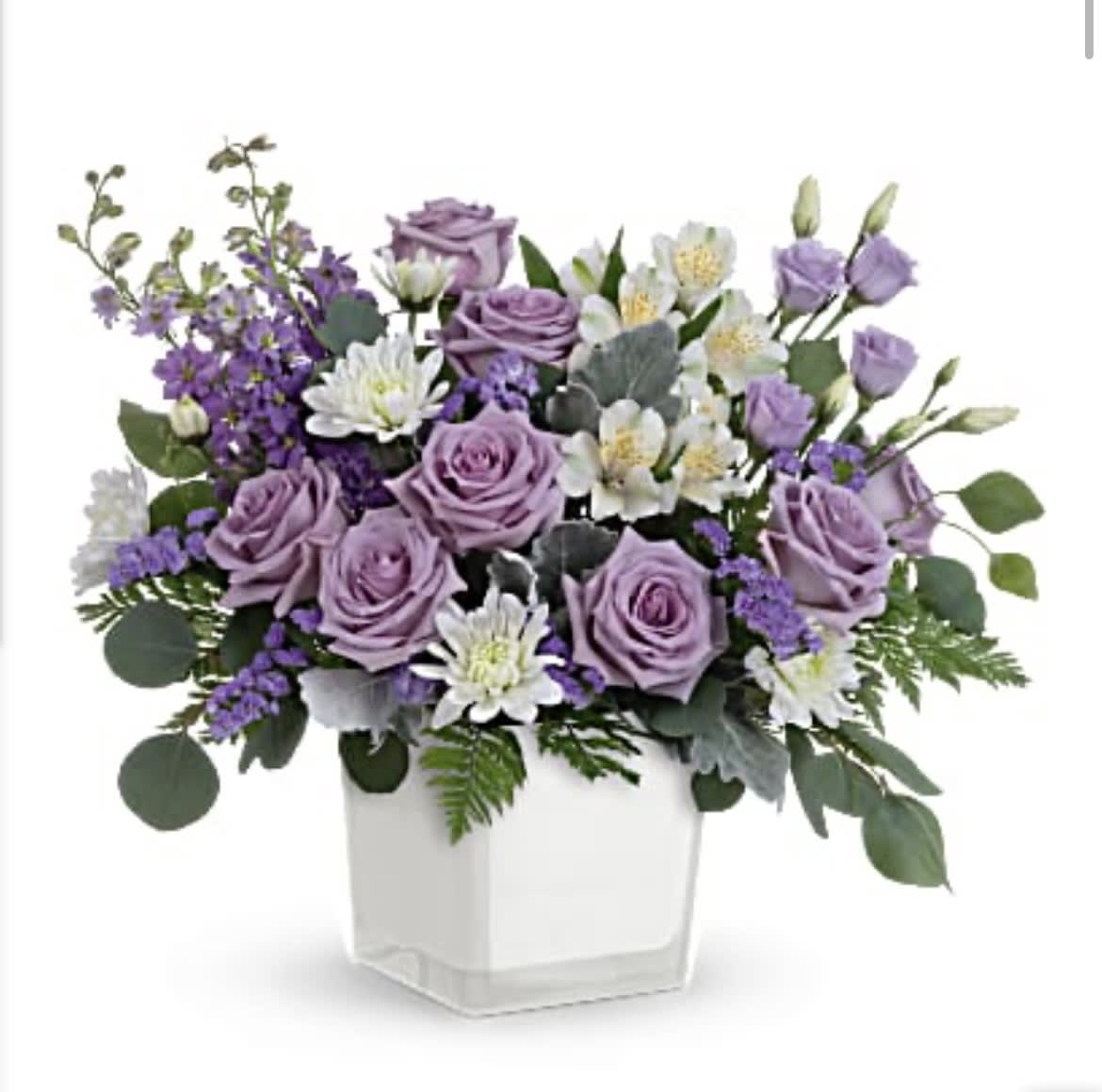 Honey Lavender Blooms Bouquet - Loveliest lavender! Make any day feel extra special with the soft purple hues of this luxurious rose bouquet, presented in a soft white glass cube. Lavender roses, white alstroemeria, lavender lisianthus, lavender larkspur, white cushion spray chrysanthemums and lavender sinuata statice are arranged with dusty miller, leatherleaf fern and silver dollar eucalyptus. Delivered in Teleflora's Color Splash cube. Orientation: All-Around