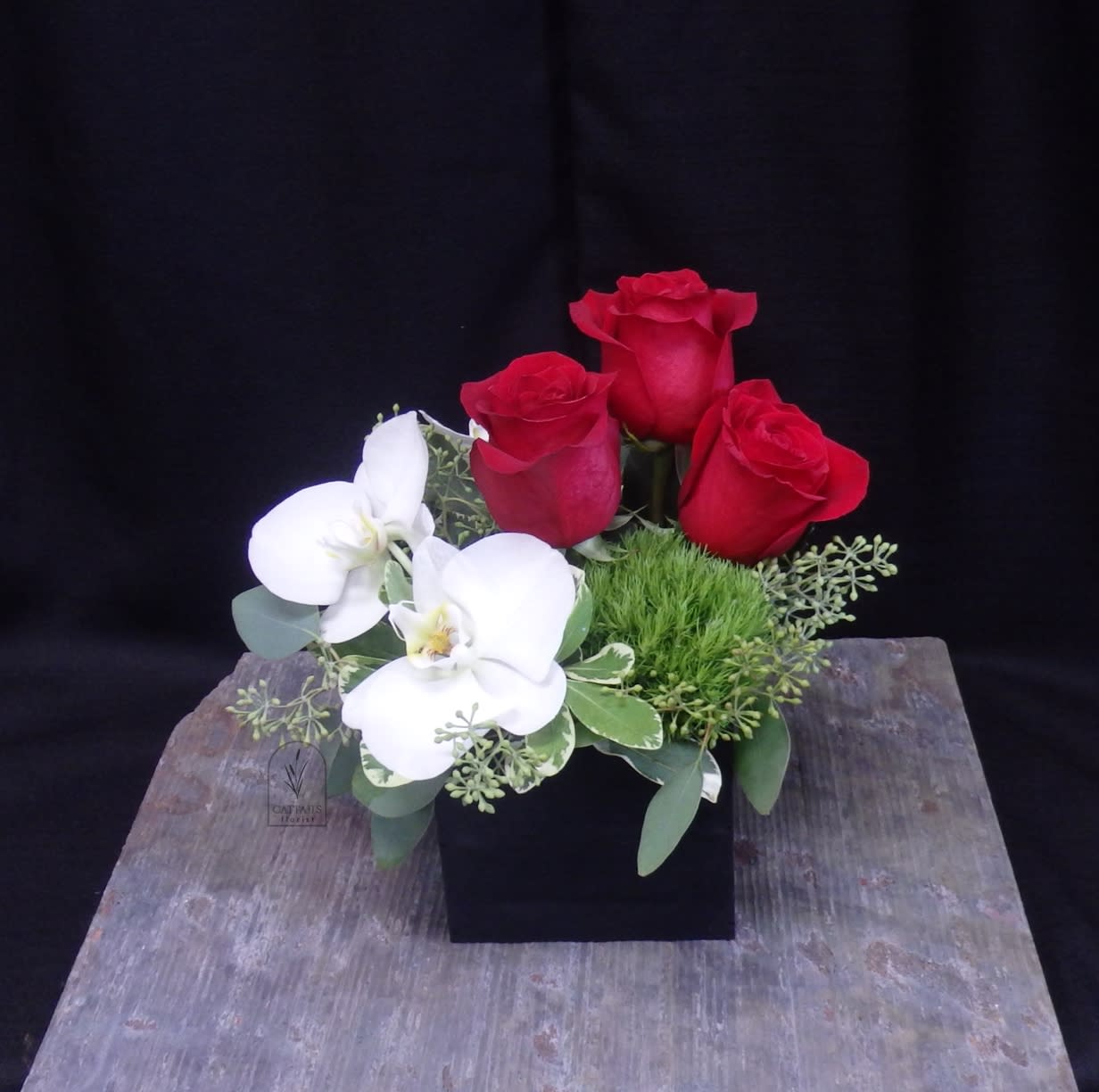 Make me Blush - Make Me Blush – A charming mix of classic red roses paired with elegant white orchids, accented with green trick in a modern black wood box. This romantic arrangement is both bold and graceful, and a perfect choice to send a small romantic, unique gesture excellent for expressing love and admiration.  