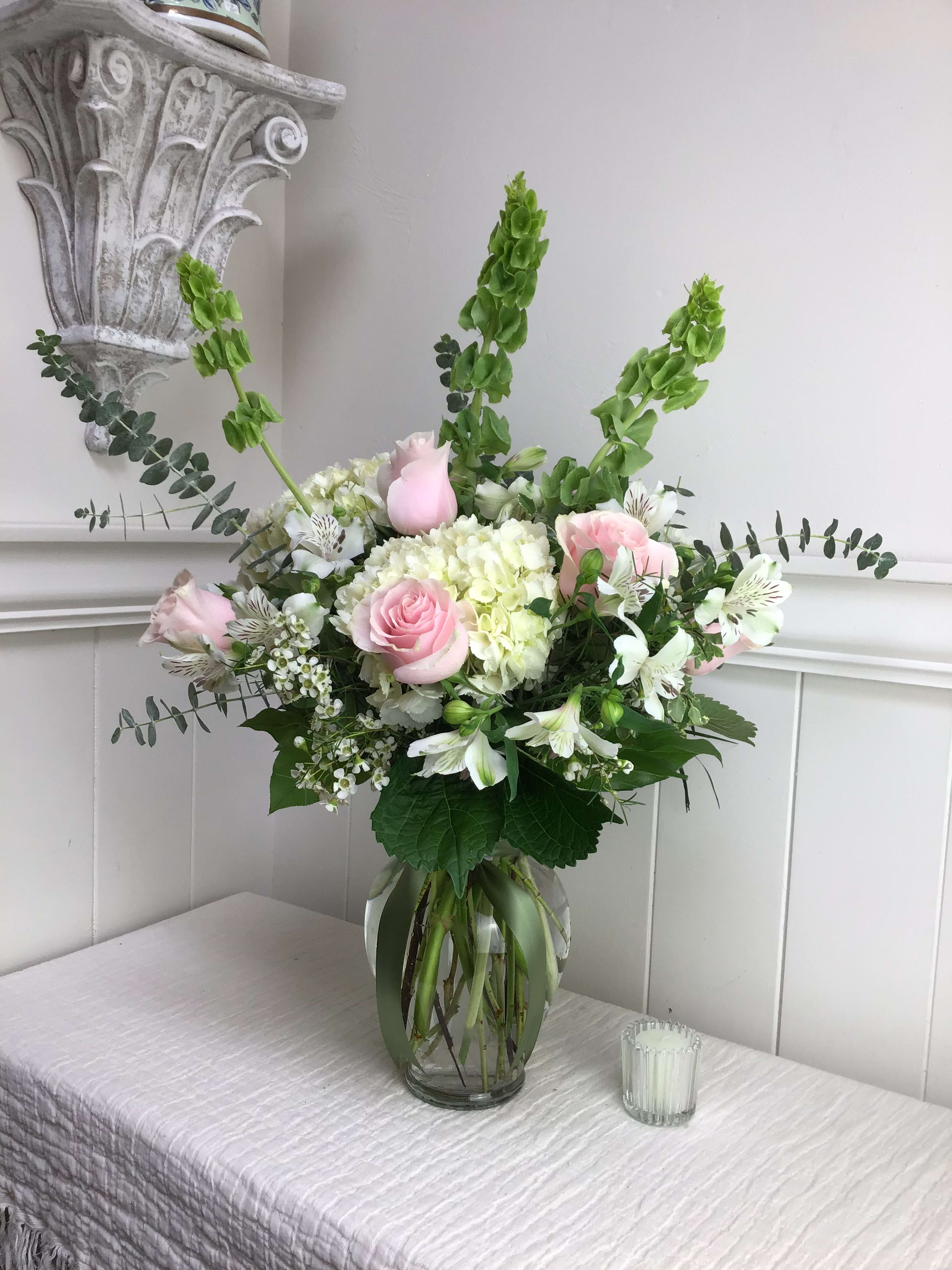 Blush - Pink and white flowers include a colorful collection of soft pink roses, Bells of Ireland, white hydrangea, and alstromeria. Large and abundant!