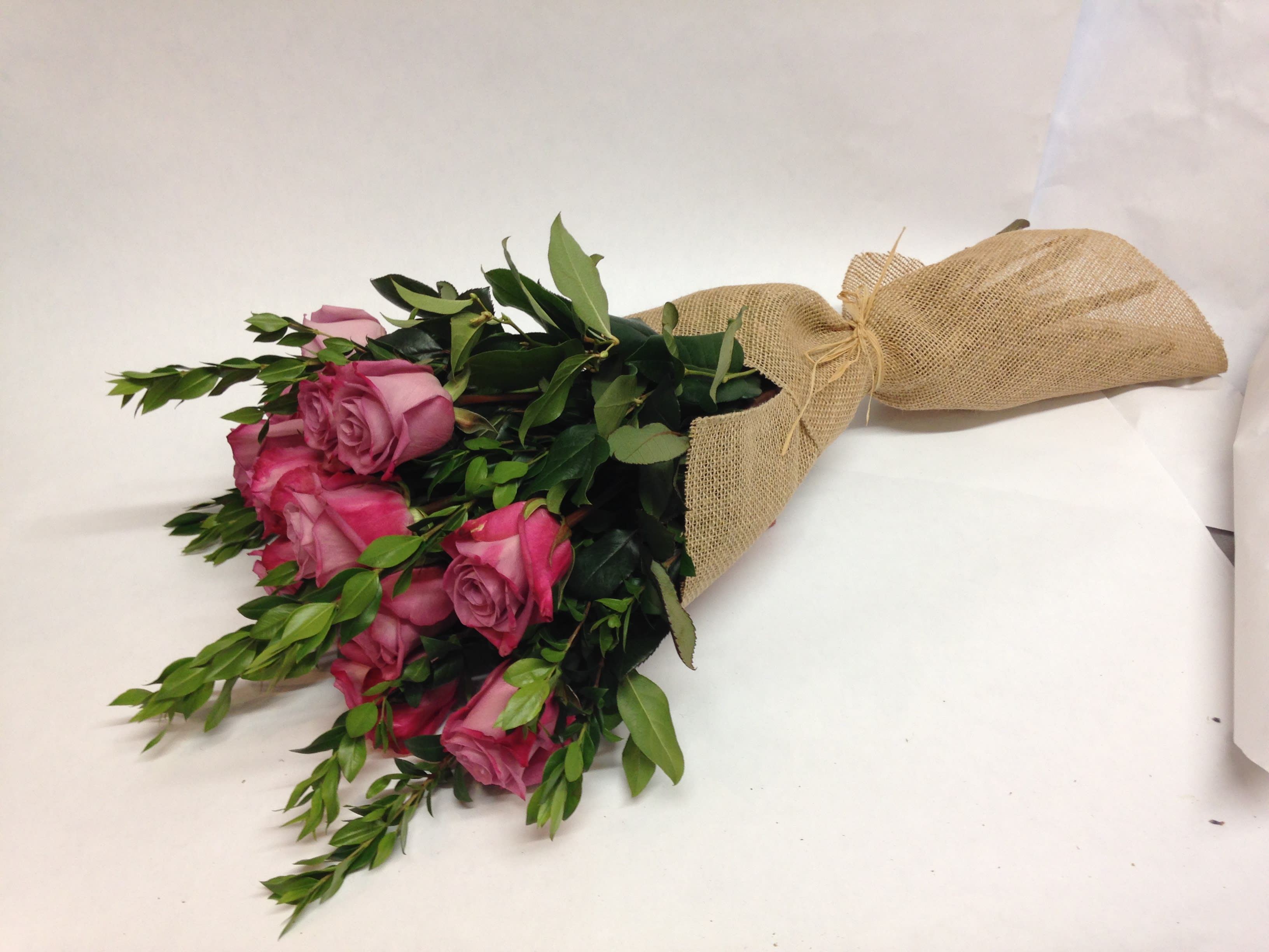Half A Dozen Premium Lavender Roses in a Burlap Wrap  - This arrangement is comprised of six premium lavender roses with various greenery wrapped in burlap. We also offer:  peach, pink, red, white, orange and hot pink colors.     (Some flowers may be subject to change depending on the season. We will contact you with available flower substitutions; please contact us with specific questions if you are concerned with flower availability, thanks!)  Featured Arrangement: $69.75  - 6  roses (REGULAR PRICE);  $129.75 -12 roses (DELUXE RRICE);    $229,75 - 24 roses  ( PREMIUM PRICE).