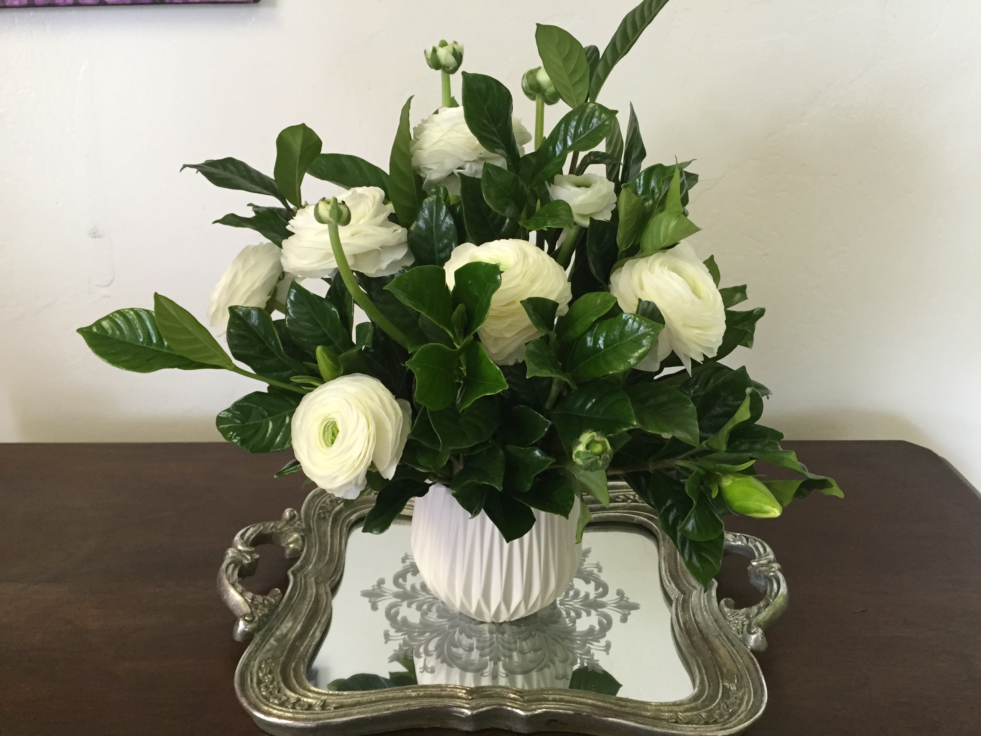 Classic Elegance - White is classic, beautiful and elegant.  White ranunculas pop against lush gardenia greenery in this lovely flower arrangement. 