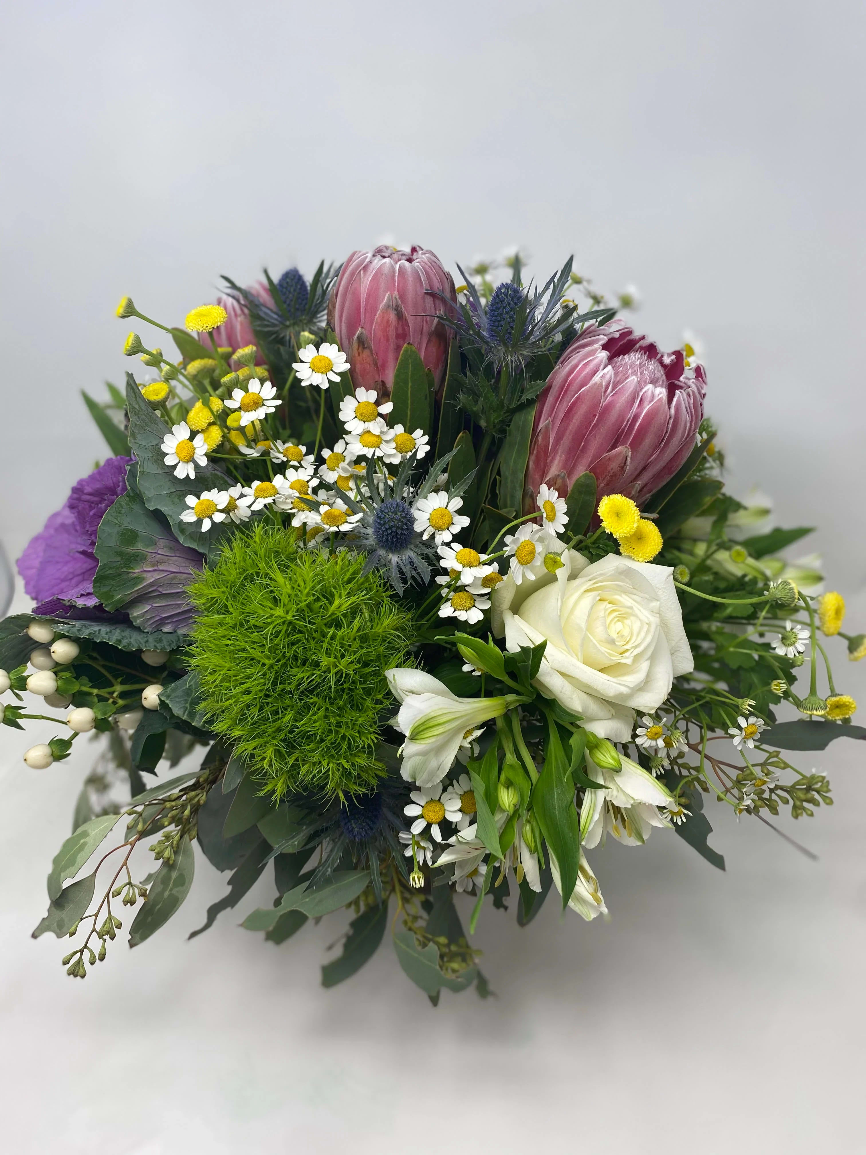Wild About U  - May contain Protea, Roses , Camille, Dianthus, Alstroemeria , and cabbage roses. 