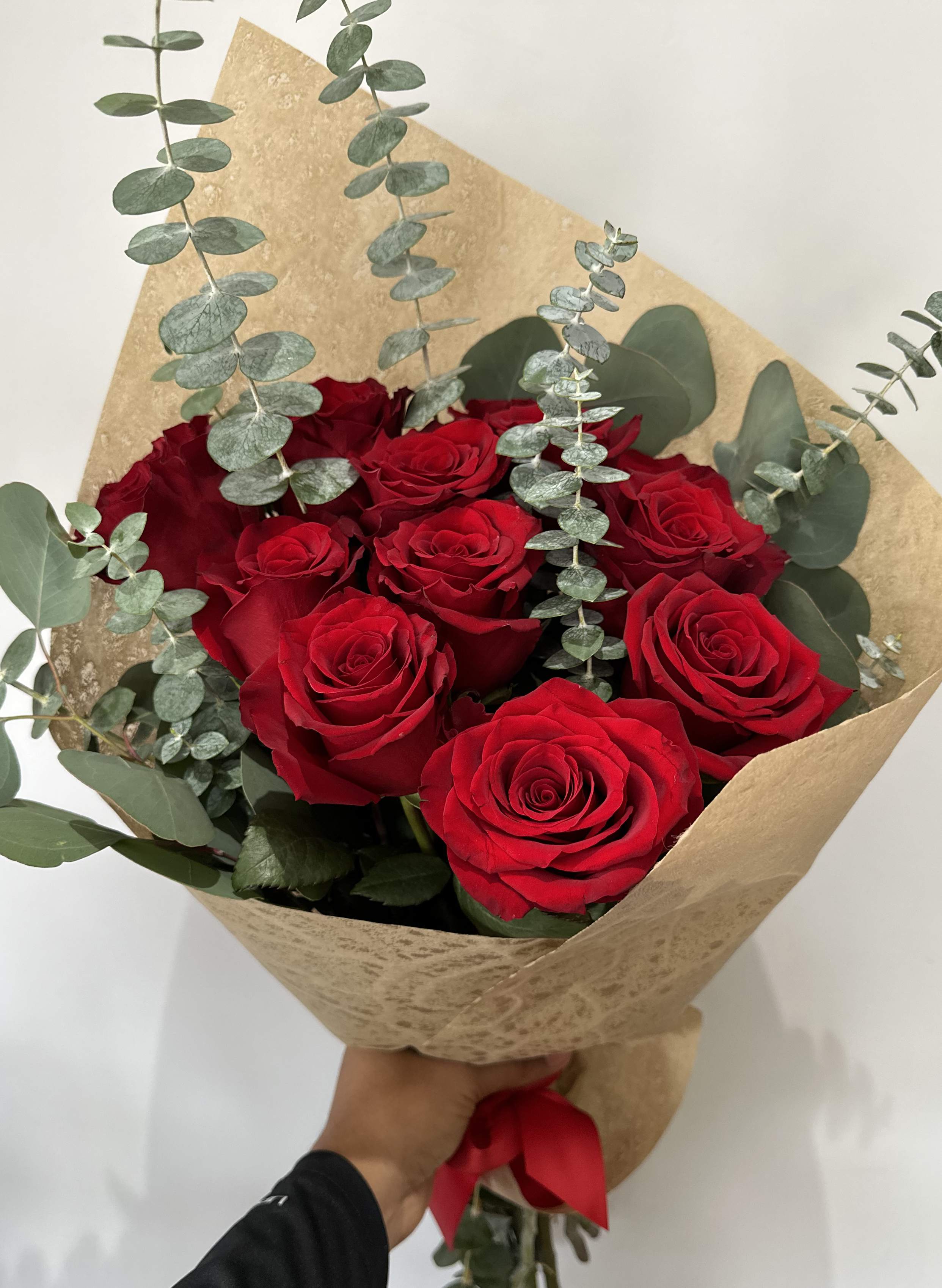Roses and Eucalyptus Bouquet - 1 Dozen Red Roses arranged with eucalyptus into a hand-tied bouquet (no vase). 