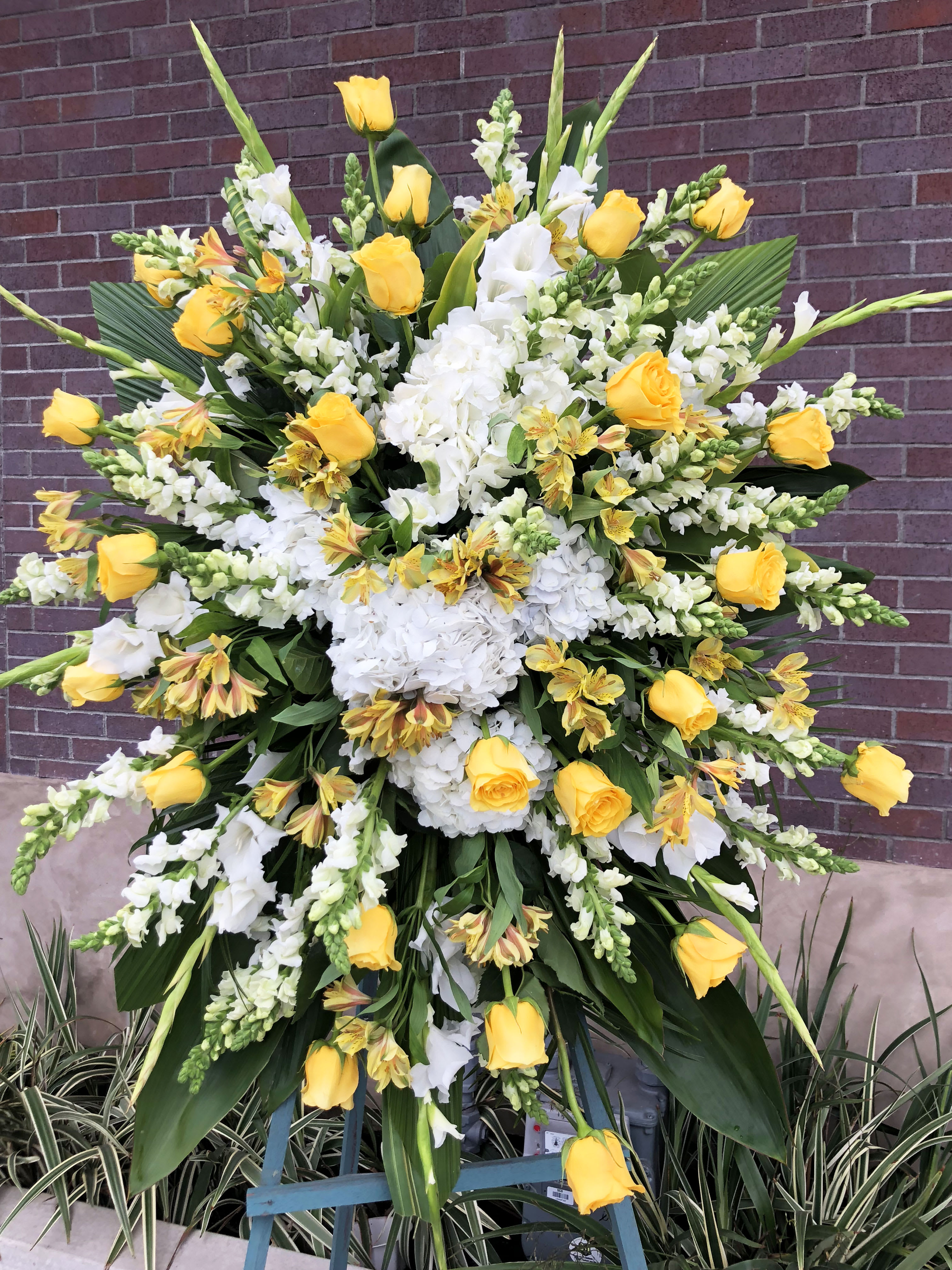Elegant Yellow  - Yellow flowers are used with a mix of green and whites. Every funeral piece includes a standing isle. 