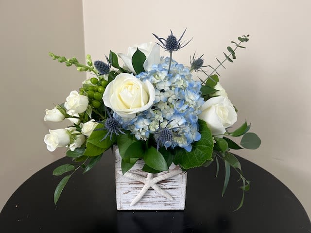 Sail Away - Whitewash wooden box with nautical starfish filled with blue hydrangea, white roses, white spray roses, white stock, mixed greens and thistle.