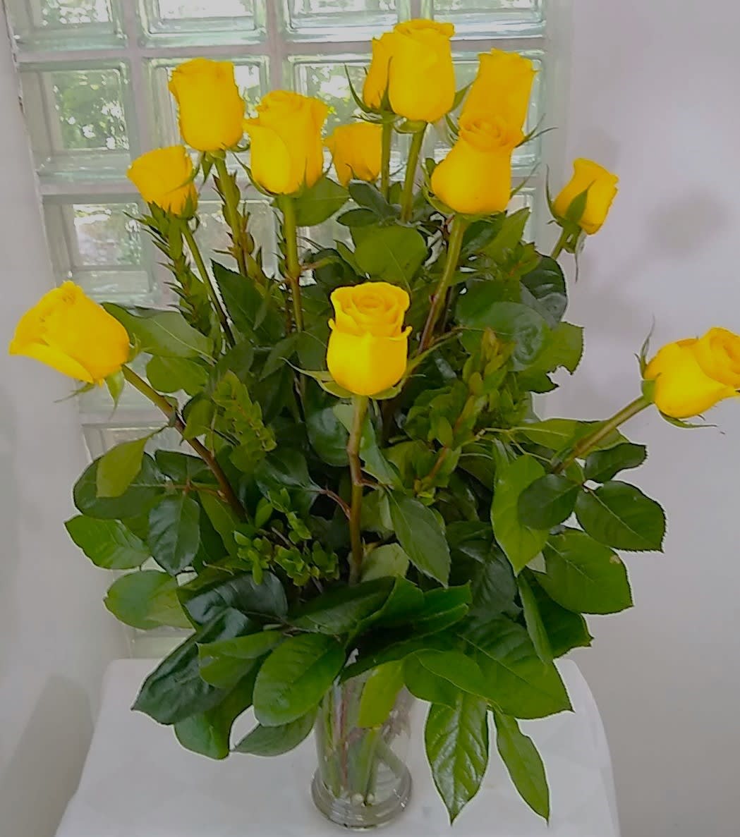 Long Stem Yellow Rose Bouquet - Yellow Rose Bouquet is a spectacular way to offer hope and warmth to those facing the loss of a loved one. Sunlit yellow roses are arranged with seeded eucalyptus in a clear glass vase to create the perfect gift of caring kindness that expresses your deepest sympathies.