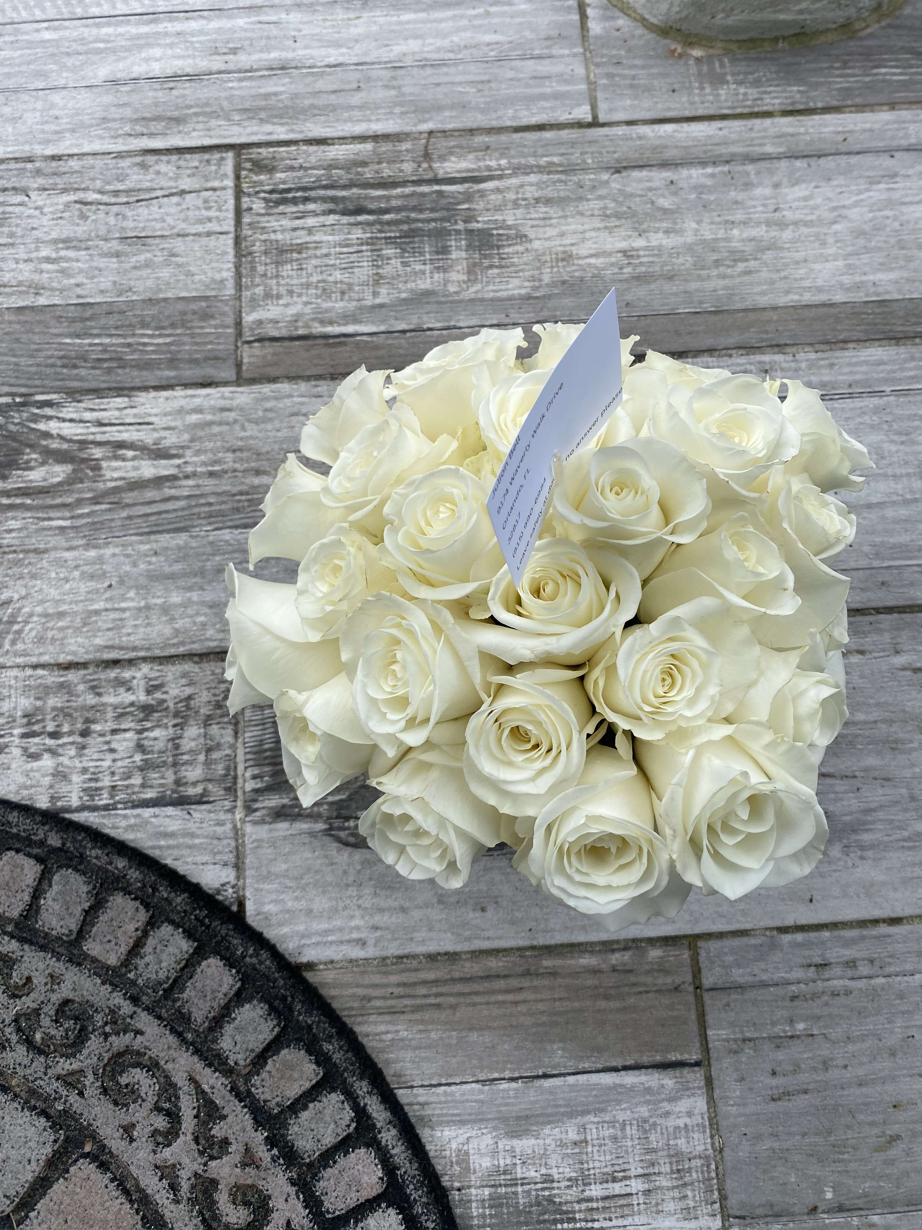 Two Dozen White Roses by BloomNation™ - Make a bold statement with this elegantly simple design. White roses symbolize hope, honor, adoration, and innocence. Two Dozen White Roses by BloomNationâ¢ is the perfect gift to welcome new beginnings or show your respects.    Arrangement Details: Three dozen red roses in a glass cylinder vase.  