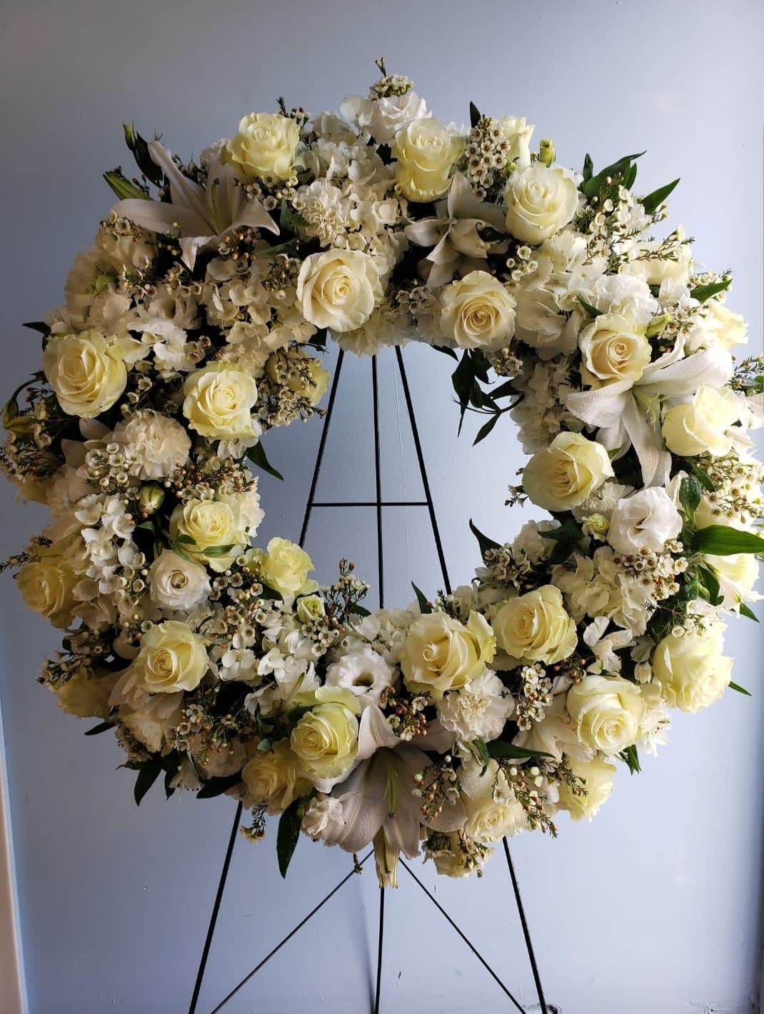 Eternal Wreath - Traditional funeral wreath filled with seasons best white flowers such as roses, hydrangea, lilies, &amp; lisianthus; completed with beautiful wax flower.  At Belden's Florist we stand behind the quality of our products. We guarantee that our flowers will remain fresh and beautiful for 3-5 days after delivery. As cut flowers, they may naturally start to wilt beyond this timeframe. However, we ensure that you receive the freshest blooms possible, carefully selected and expertly arranged to bring joy and elegance to your space. To help your flowers stay fresher longer, we recommend adding fresh water to the vase regularly. Just like you, flowers need hydration to thrive, and refreshing the water allows them to drink up and continue to dazzle you with their beauty.