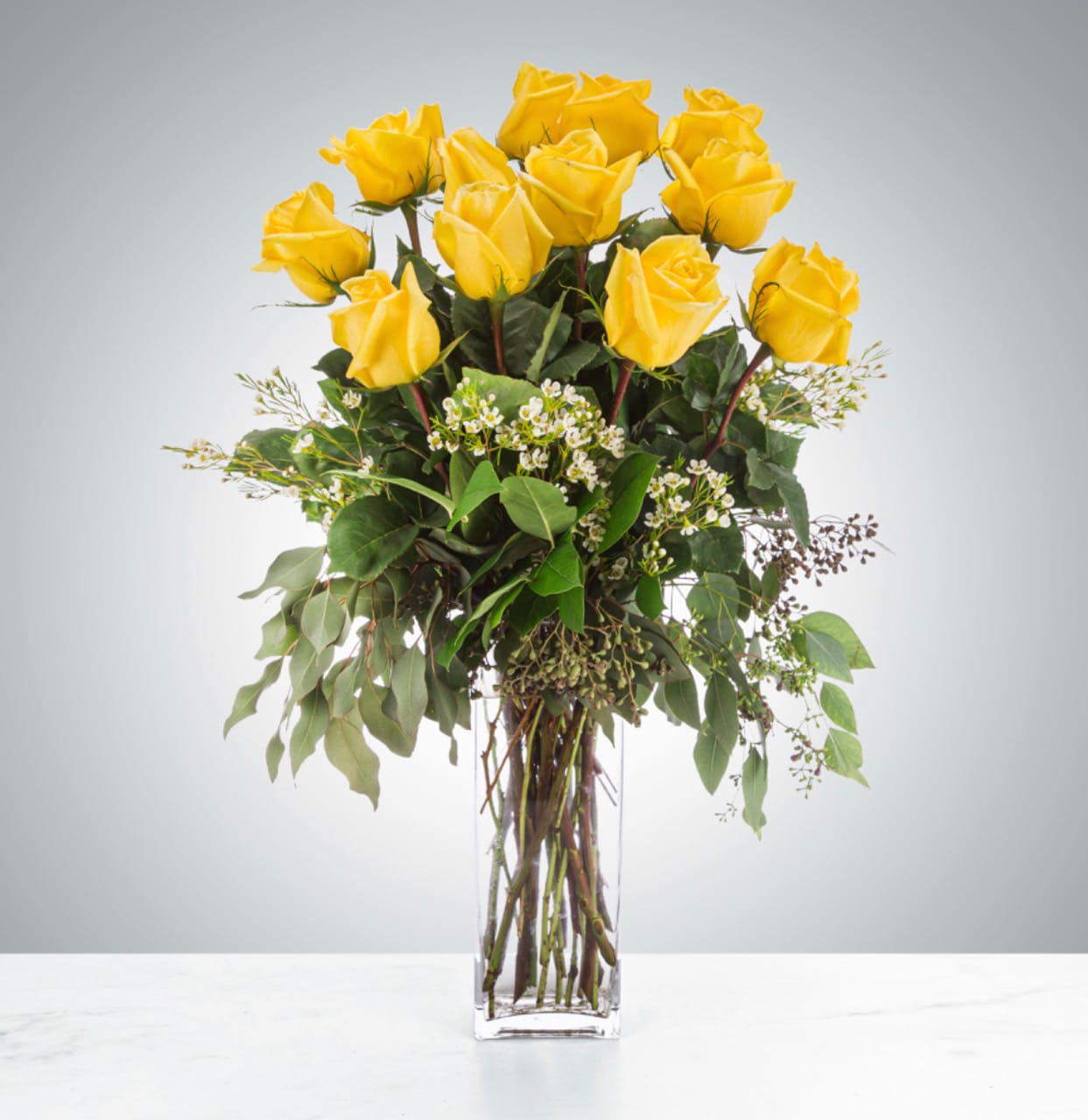 Felicitations  - Send a dozen yellow roses to brighten up their space and celebrate them! Accented with premium greeneries and available filler flowers such as waxflower or baby's breath.   Approximate Dimensions: 18"D x 25"H