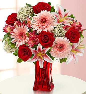 Elegant Wishes - Product ID: 90985  Whatever theyâre wanting, hoping, dreamingâ¦ each of the hand-selected flowers in this truly original arrangement -- roses, Gerberas, lilies, alstroemeria and rice flowers combines to fulfill their wish to have fresh flowers delivered to the door. Hand-gathered arrangement of roses, lilies, Gerbera daisies, alstroemeria, rice flowers and variegated pittosporum Artistically designed in a Red Glass Gathering Vase; measures 9"H Large arrangement measures approximately 20"H x 16"L Medium arrangement measures approximately 19"H x 14"L Small arrangement measures approximately 17"H x 12"L Our florists hand-design each arrangement, so colors, varieties, and container may vary due to local availability Lilies may arrive in bud form and will open to full beauty over the next 2-3 days